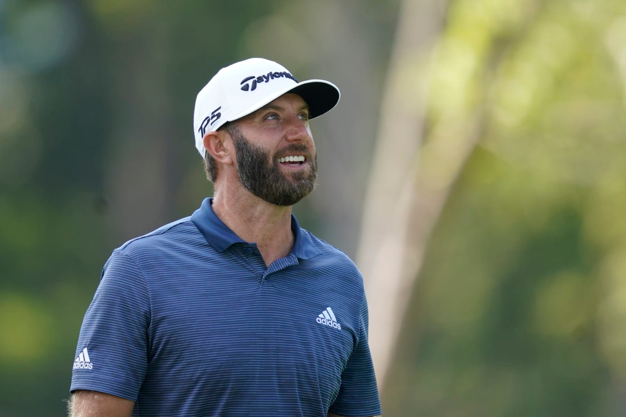Dustin Johnson looks at the trees he hit his tee shot over on the 12 hole during the first round off the LIV Golf Invitational-Chicago tournament Friday, Sept. 16, 2022, in Sugar Grove, Ill. (AP Photo/Charles Rex Arbogast)
