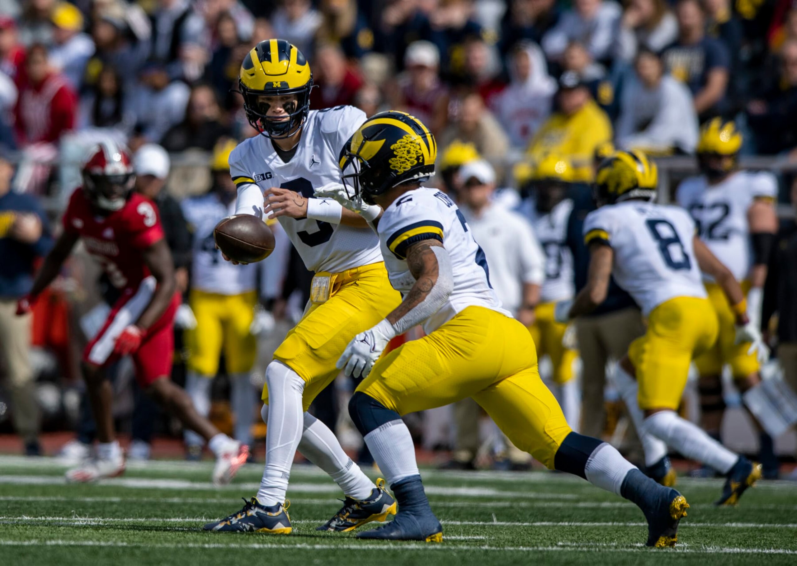 Michigan quarterback J.J. McCarthy (9) hands off to running back Blake Corum (2) during an NCAA college football game, Saturday, Oct. 8, 2022, in Bloomington, Ind. (AP Photo/Doug McSchooler)