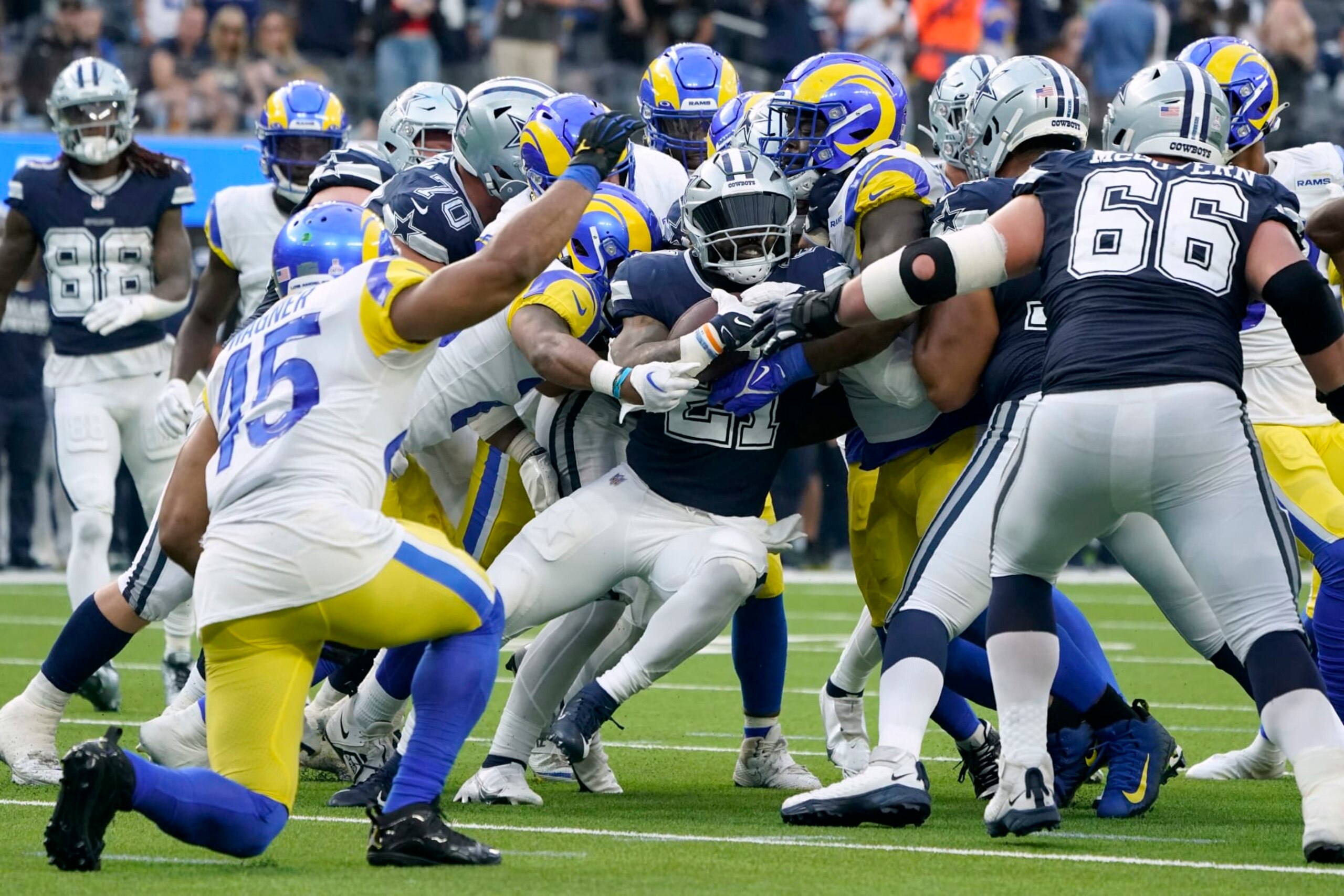 Dallas Cowboys running back Ezekiel Elliott (21) attempts to run the ball as Los Angeles Rams' Bobby Wagner (45) and Connor McGovern (66) look on in the second half of an NFL football game, Sunday, Oct. 9, 2022, in Inglewood, Calif. (AP Photo/Marcio Jose Sanchez)