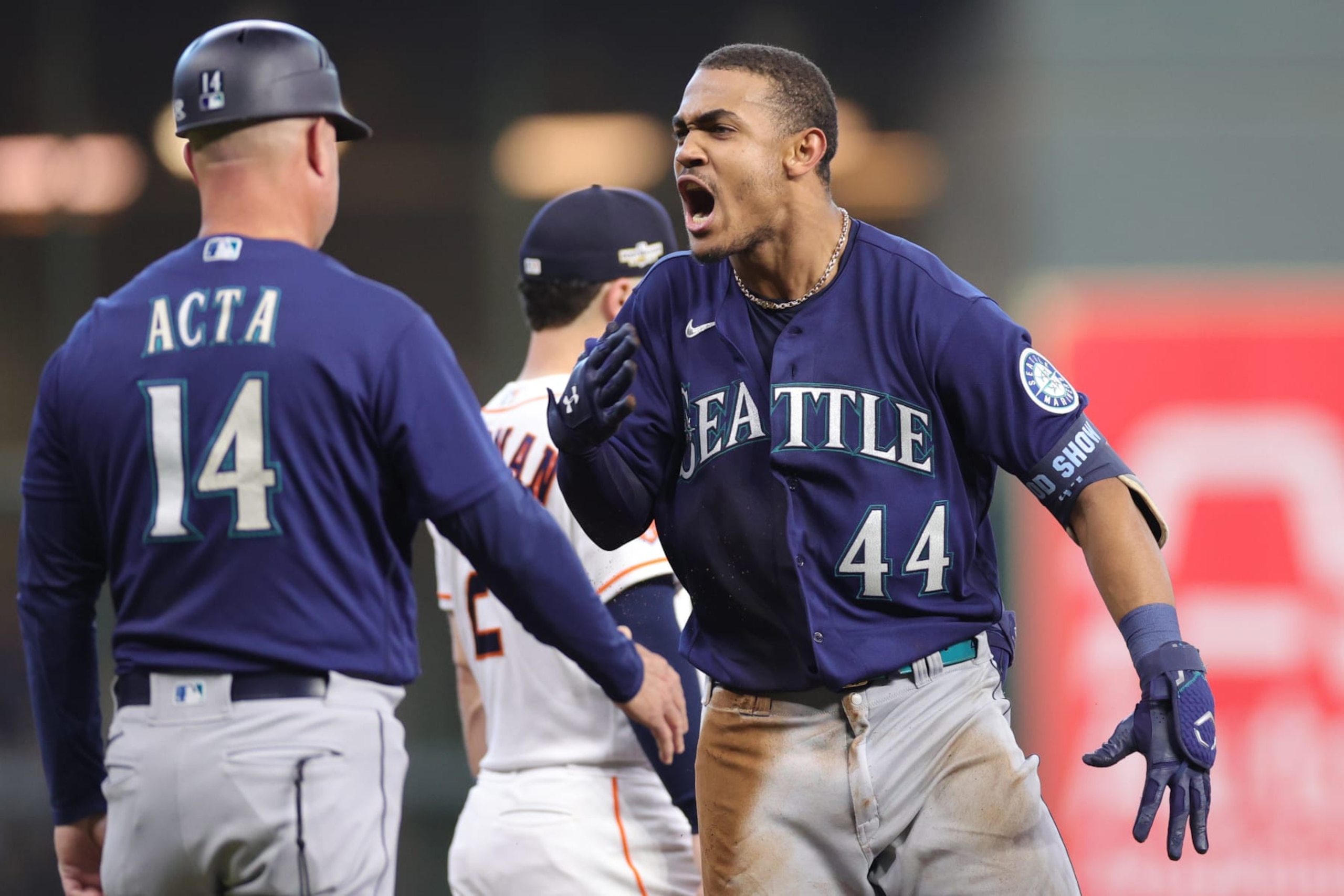 HOUSTON, TEXAS - OCTOBER 11: Julio Rodriguez #44 of the Seattle Mariners celebrates his triple against the Houston Astros with Manny Acta #14 during the fourth inning in game one of the American League Division Series at Minute Maid Park on October 11, 2022 in Houston, Texas. (Photo by Carmen Mandato/Getty Images)