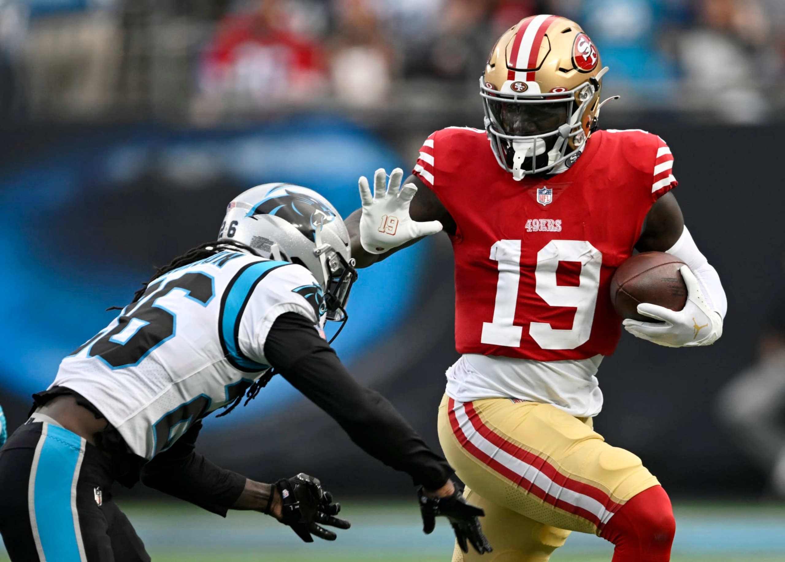 CHARLOTTE, NORTH CAROLINA - OCTOBER 09: Deebo Samuel #19 of the San Francisco 49ers gets tackled by Donte Jackson #26 of the Carolina Panthers in the third quarter at Bank of America Stadium on October 09, 2022 in Charlotte, North Carolina. (Photo by Eakin Howard/Getty Images)