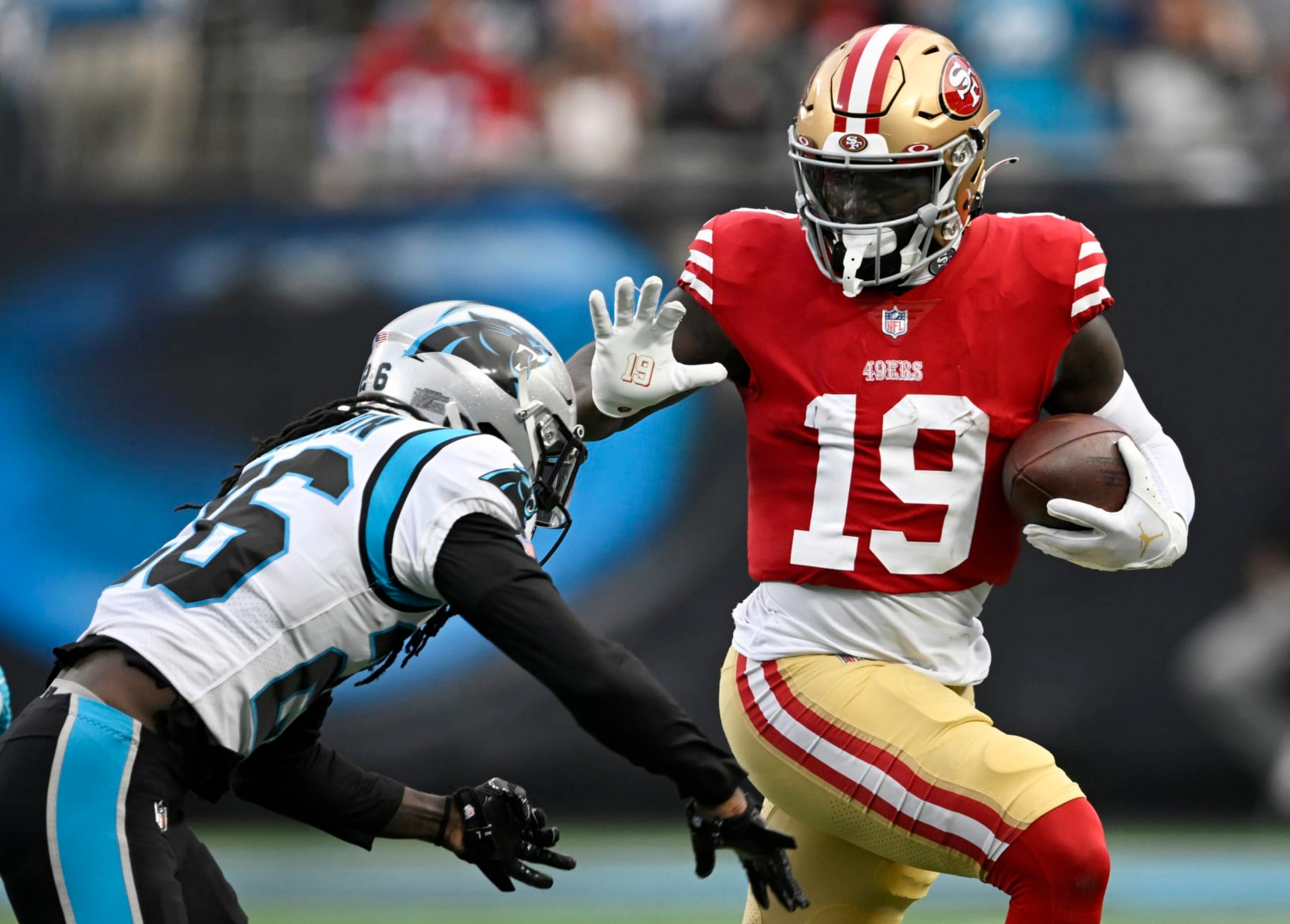 CHARLOTTE, NORTH CAROLINA - OCTOBER 09: Deebo Samuel #19 of the San Francisco 49ers gets tackled by Donte Jackson #26 of the Carolina Panthers in the third quarter at Bank of America Stadium on October 09, 2022 in Charlotte, North Carolina. (Photo by Eakin Howard/Getty Images)