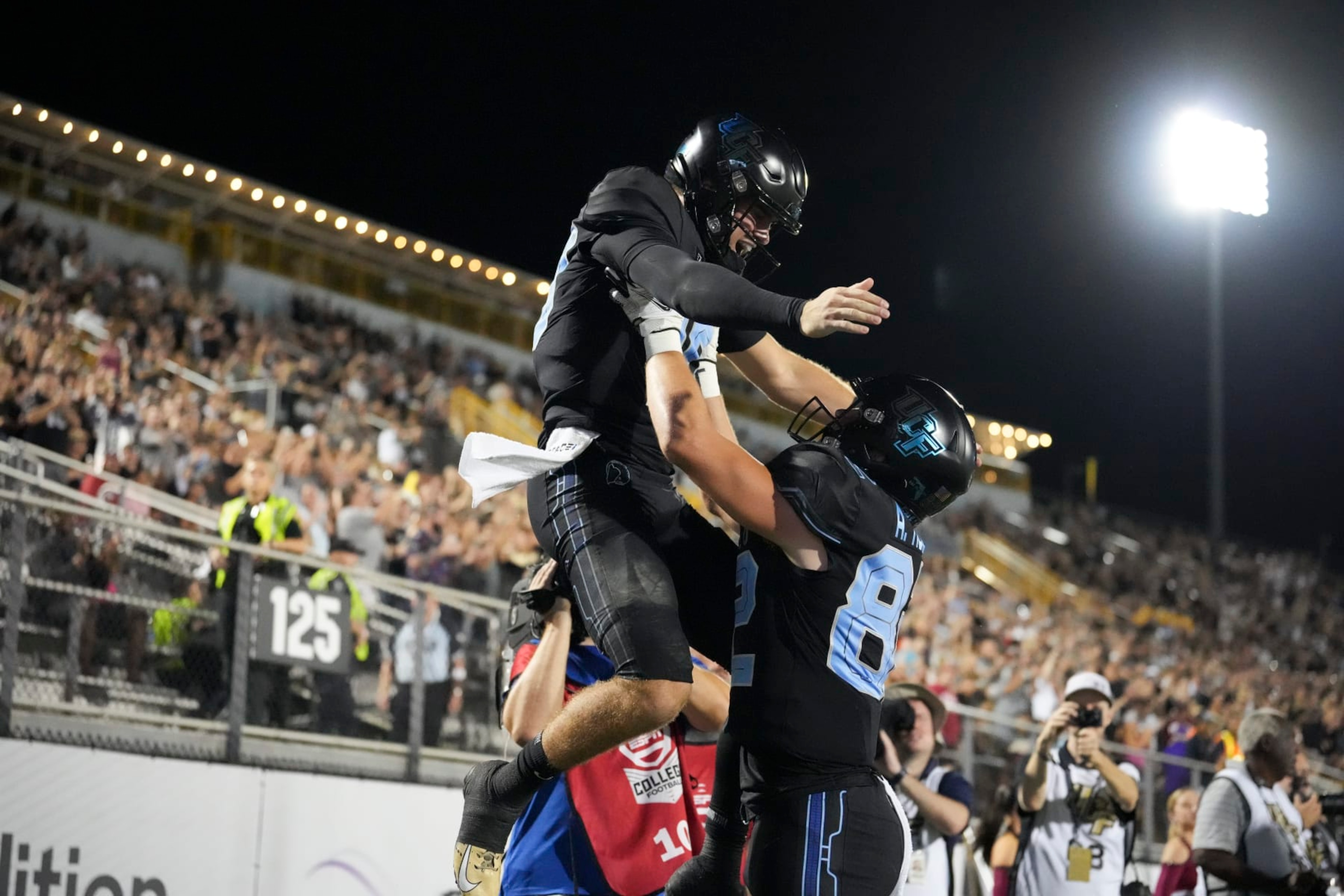 ORLANDO, FL - OCTOBER 13: UCF Knights quarterback John Rhys Plumlee (10) gets lifted up by UCF Knights tight end Alec Holler (82) after his touchdown run during the game between the Temple Owls and the University of Central Florida (UCF) Knights on Thursday, October 13, 2022 at Bright House Networks Stadium in Orlando, FL (Photo by Peter Joneleit/Icon Sportswire via Getty Images)