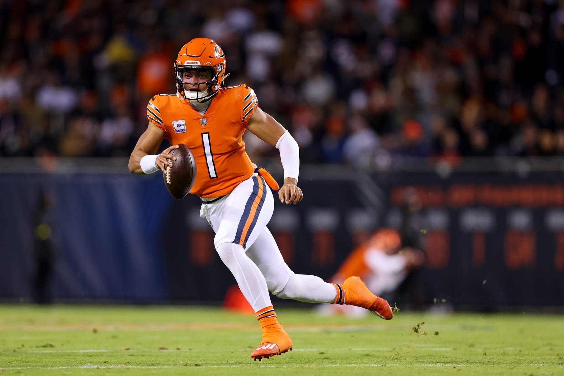 CHICAGO, ILLINOIS - OCTOBER 13: Justin Fields #1 of the Chicago Bears carries the ball during the first quarter against the Washington Commanders at Soldier Field on October 13, 2022 in Chicago, Illinois. (Photo by Michael Reaves/Getty Images)