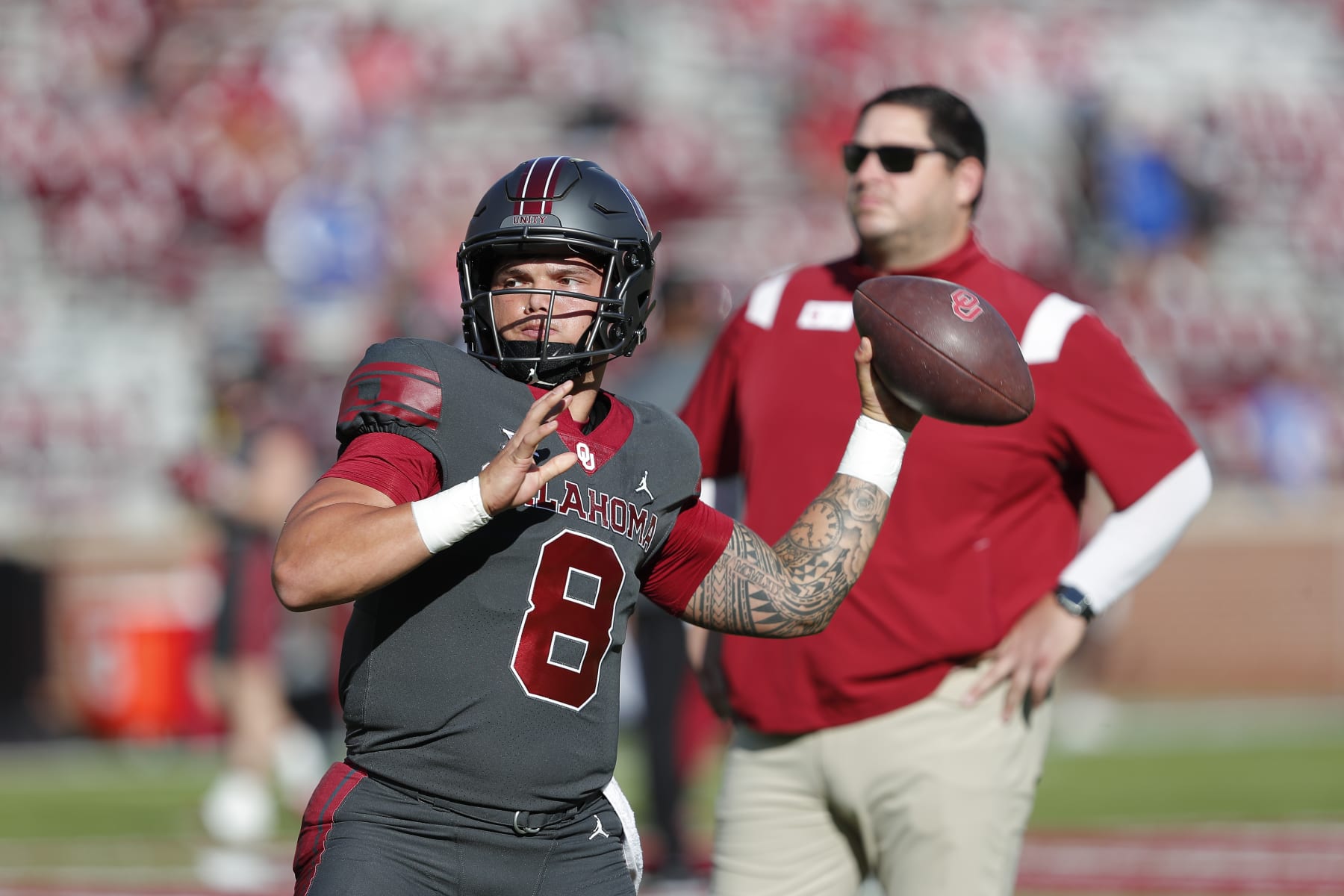 Oklahoma quarterback Dillon Gabriel (8) warms up as offensive coordinator Jeff Lebby watches from the background before the start of an NCAA college football game against Kansas on Saturday, Oct. 15, 2022, in Norman, Okla. (AP Photo/Alonzo Adams)