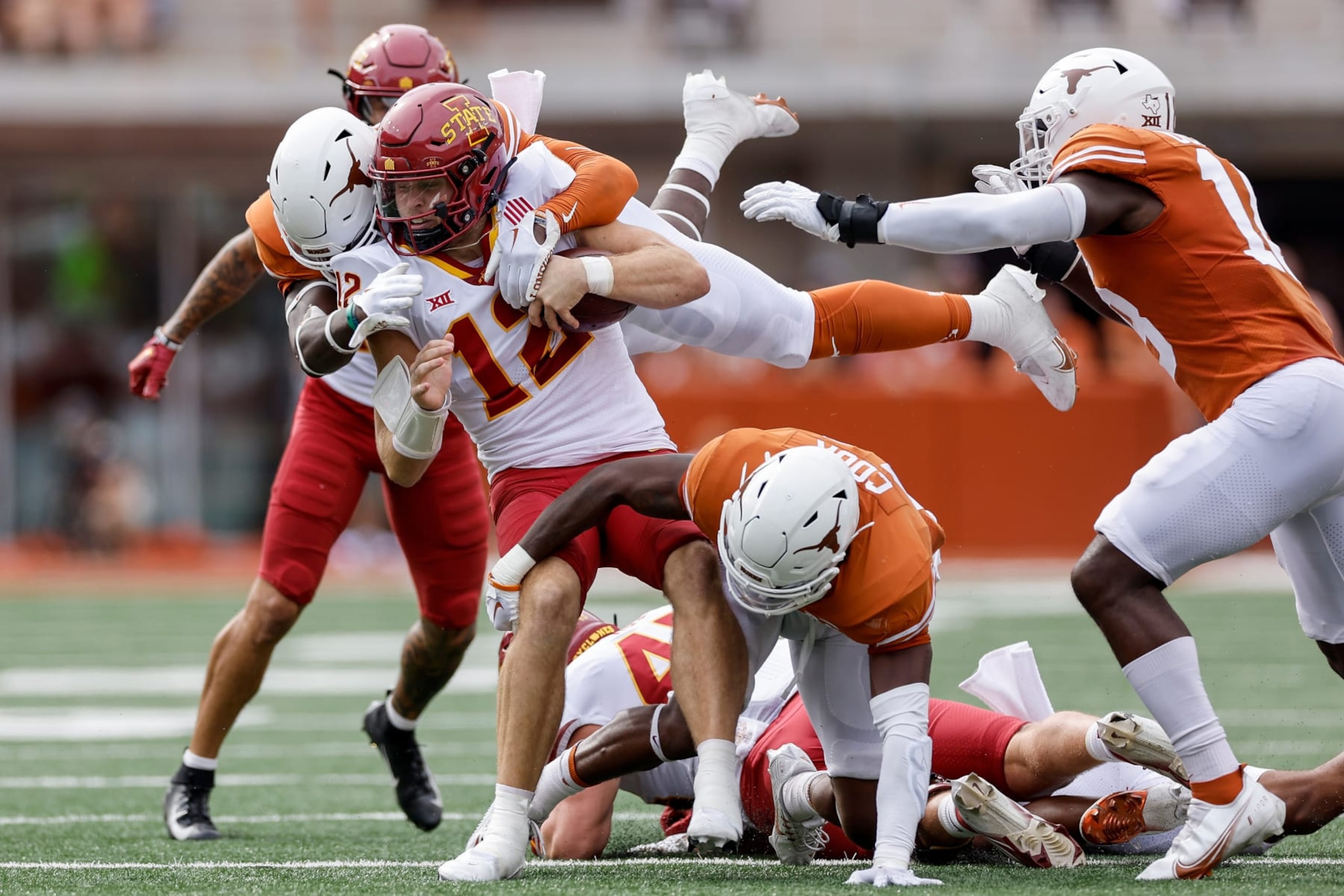 AUSTIN, TEXAS - OCTOBER 15: Hunter Dekkers #12 of the Iowa State Cyclones is tackled by DeMarvion Overshown #0 of the Texas Longhorns and Anthony Cook #11 in the first quarter at Darrell K Royal-Texas Memorial Stadium on October 15, 2022 in Austin, Texas. (Photo by Tim Warner/Getty Images)