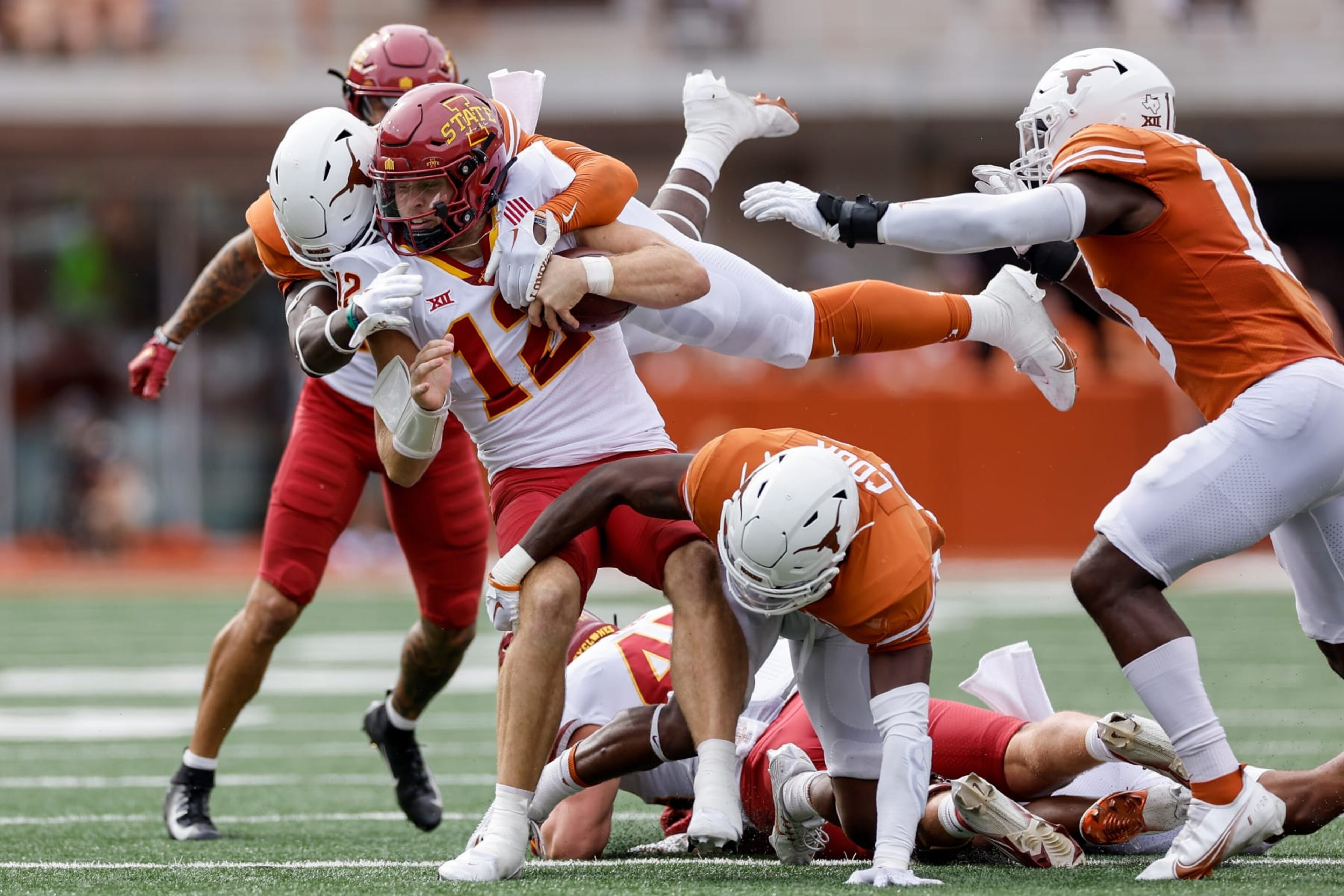 AUSTIN, TEXAS - OCTOBER 15: Hunter Dekkers #12 of the Iowa State Cyclones is tackled by DeMarvion Overshown #0 of the Texas Longhorns and Anthony Cook #11 in the first quarter at Darrell K Royal-Texas Memorial Stadium on October 15, 2022 in Austin, Texas. (Photo by Tim Warner/Getty Images)