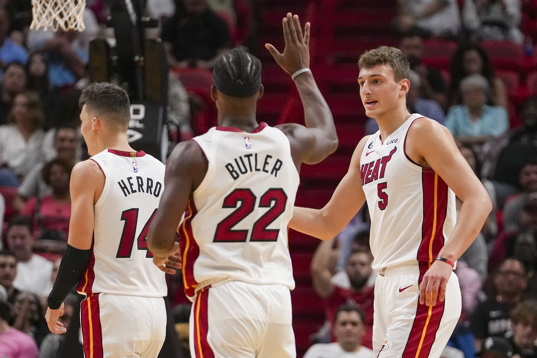 MIAMI, FLORIDA - OCTOBER 12: Nikola Jovic #5 of the Miami Heat is congratulated by Jimmy Butler #22 after making a three pointer in the first half of the game against the New Orleans Pelicans at FTX Arena on October 12, 2022 in Miami, Florida. NOTE TO USER: User expressly acknowledges and agrees that, by downloading and or using this photograph, User is consenting to terms and conditions of the Getty Images License Agreement.  (Photo by Eric Espada/Getty Images)