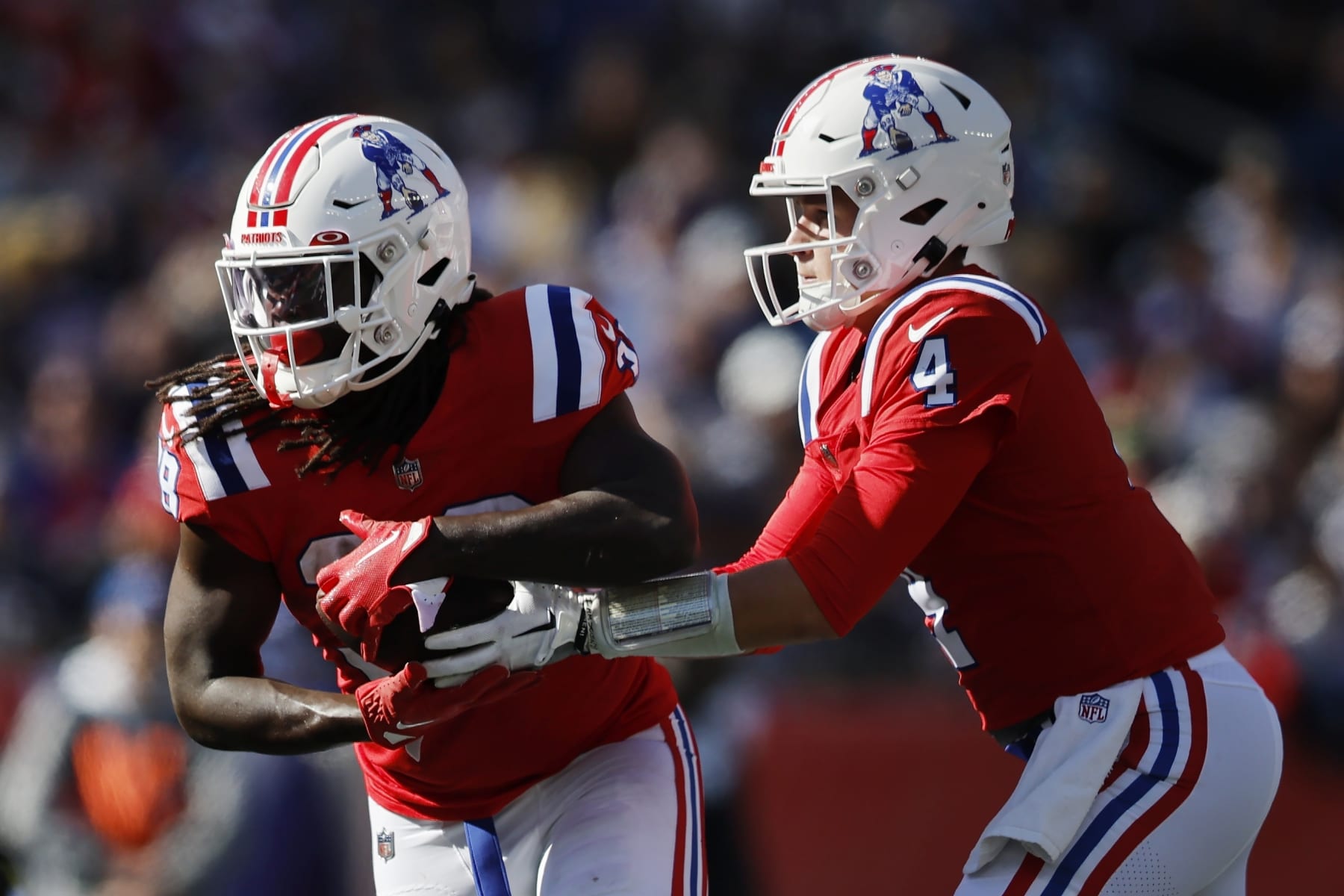 New England Patriots quarterback Bailey Zappe (4) hands off to running back Rhamondre Stevenson during the second half of an NFL football game against the Detroit Lions, Sunday, Oct. 9, 2022, in Foxborough, Mass. (AP Photo/Michael Dwyer)