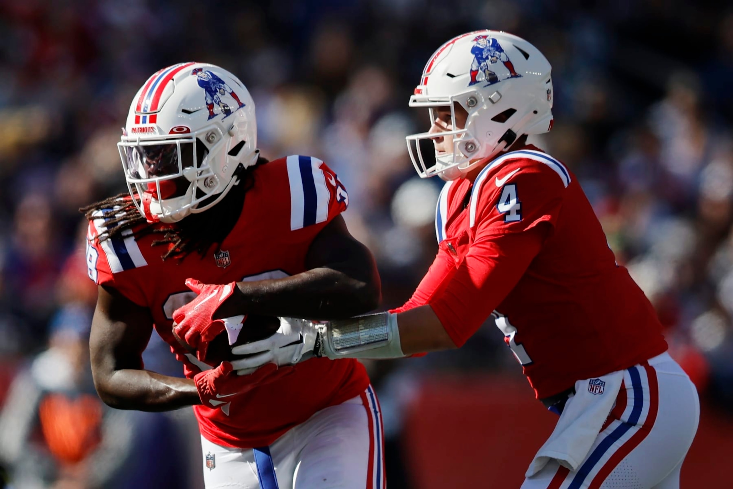 New England Patriots quarterback Bailey Zappe (4) hands off to running back Rhamondre Stevenson during the second half of an NFL football game against the Detroit Lions, Sunday, Oct. 9, 2022, in Foxborough, Mass. (AP Photo/Michael Dwyer)