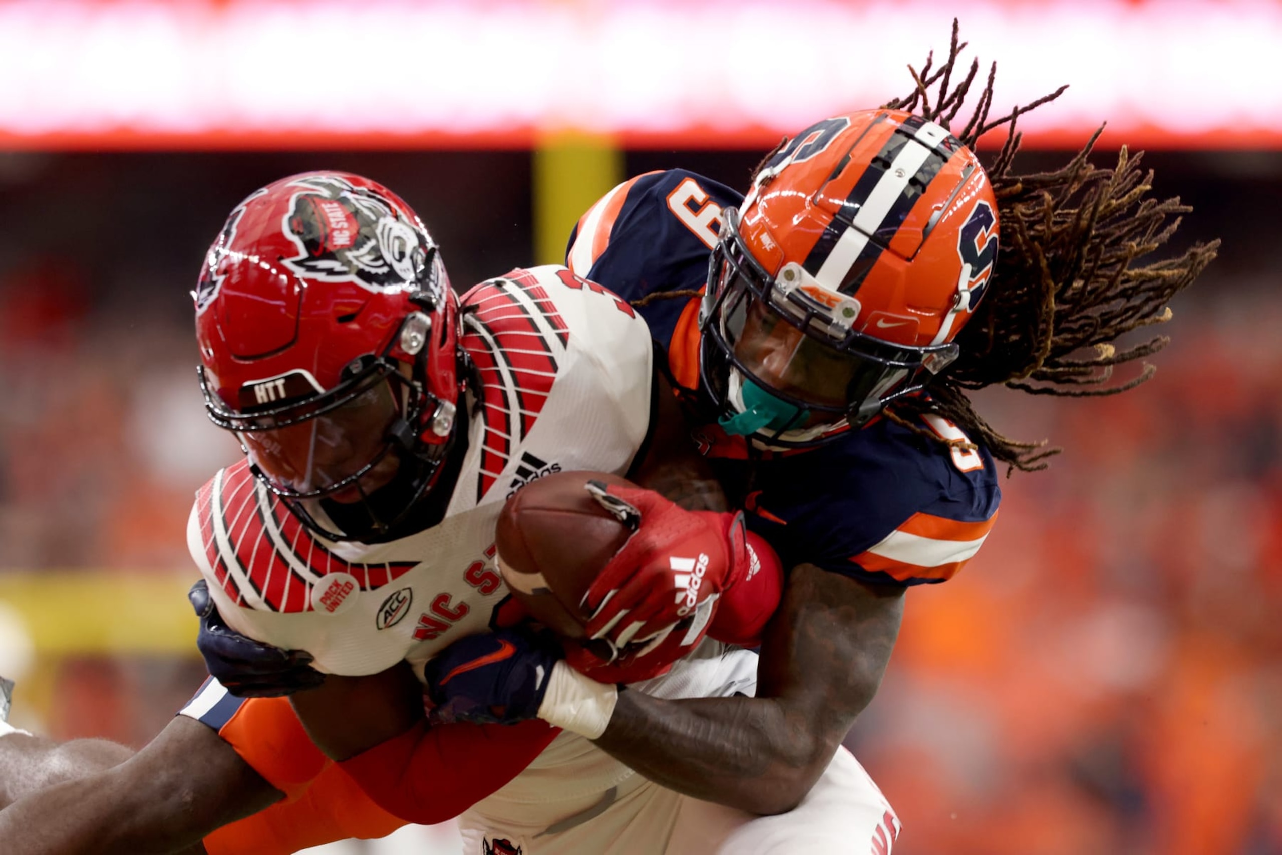 SYRACUSE, NEW YORK - OCTOBER 15: Aydan White #3 of the North Carolina State Wolfpack is tackled by Courtney Jackson #9 of the Syracuse Orange after White intercepted the ball during the second quarter at JMA Wireless Dome on October 15, 2022 in Syracuse, New York. (Photo by Bryan M. Bennett/Getty Images)