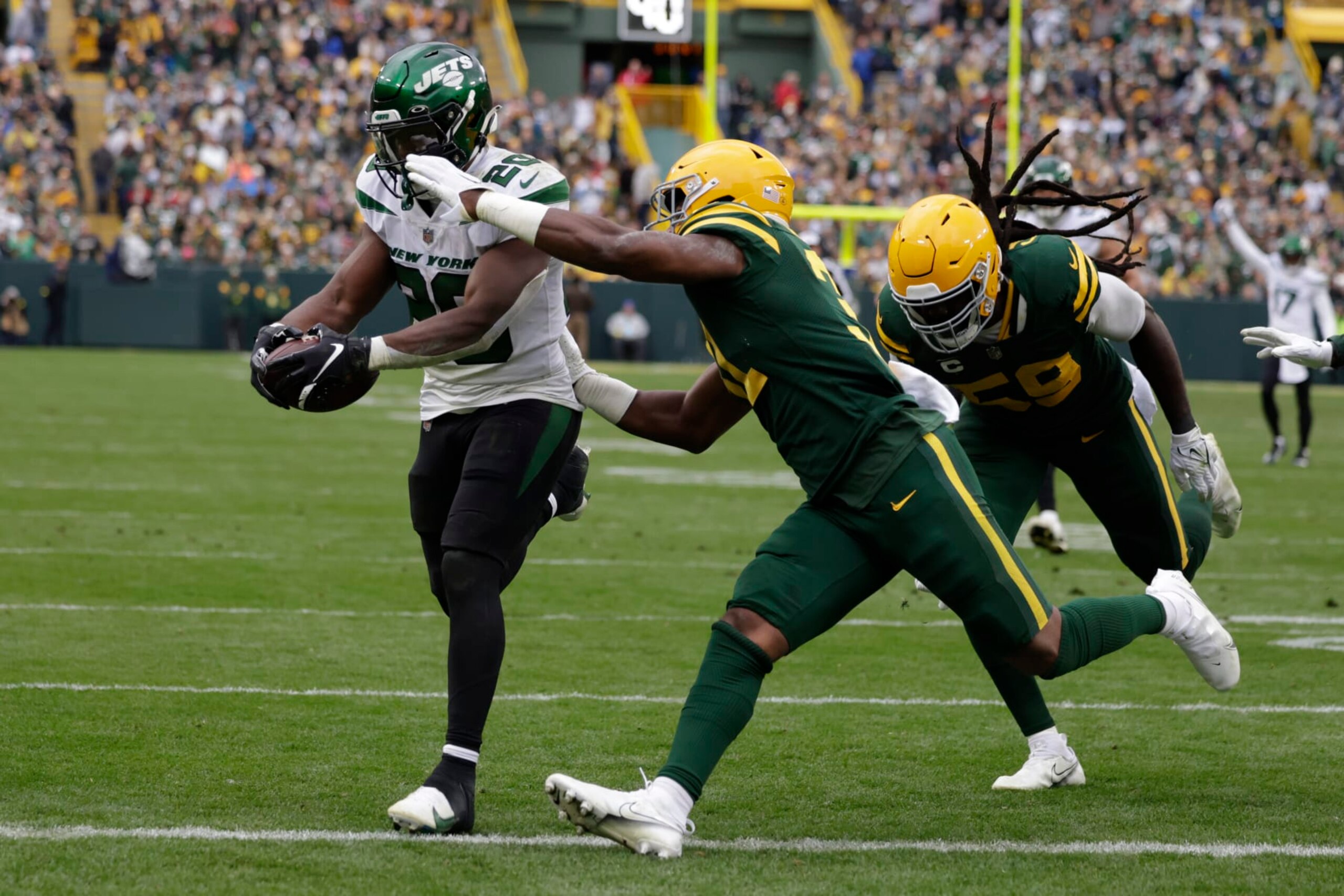 New York Jets running back Breece Hall (20), defended by Green Bay Packers safety Adrian Amos rushes for a 34-yard touchdown during the second half of an NFL football game Sunday, Oct. 16, 2022, in Green Bay, Wis. (AP Photo/Matt Ludtke)