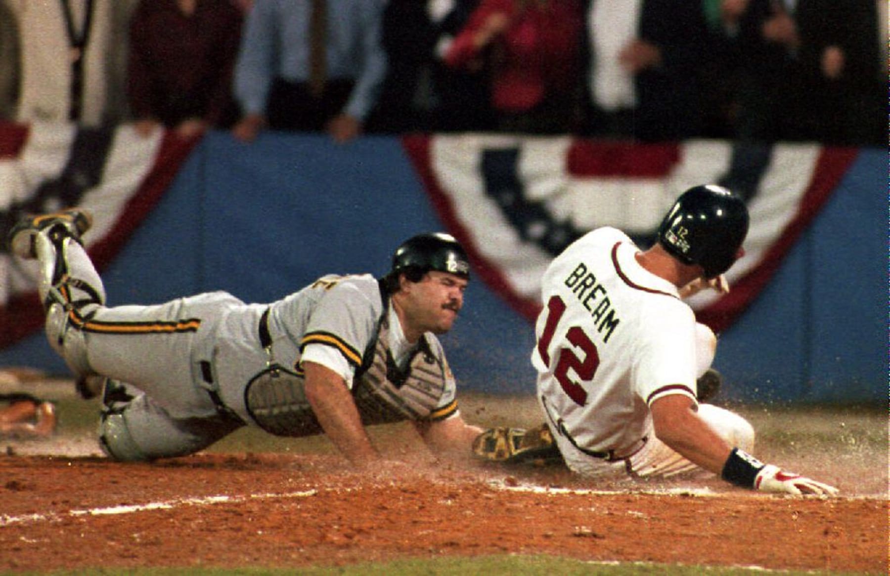 ATLANTA, GA - OCTOBER 14:  The Atlanta Braves Sid Bream (R) slides across the plate to win the National League Championship Series as the Pittsburgh Pirates catcher Mike LaValliere (L)applies the late tag in the ninth inning 14 October, 1992 in Atlanta, GA. The Atlanta Braves won the game 3-2, and will meet the Toronto Blue Jays in the World Series.  (Photo credit should read ROBERT SULLIVAN/AFP via Getty Images)
