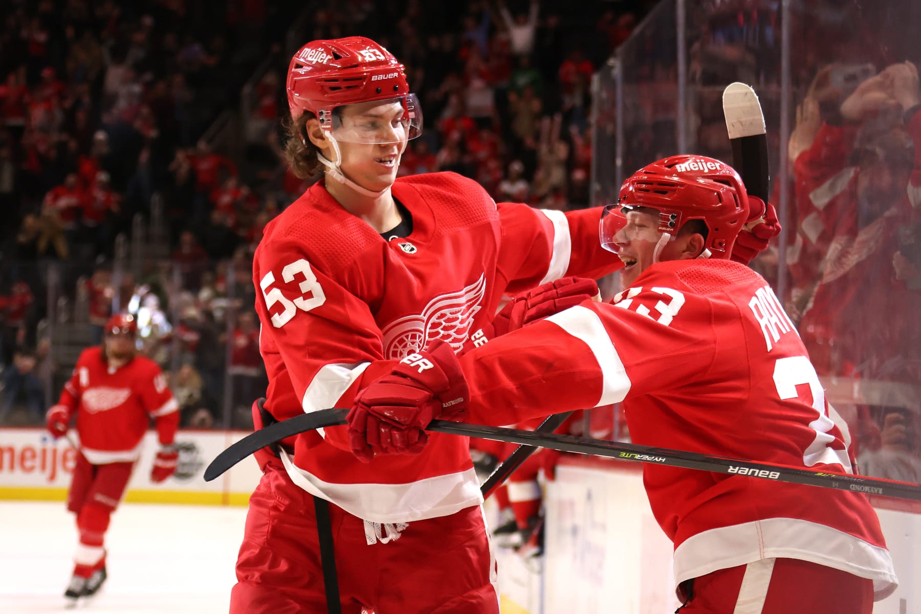 DETROIT, MICHIGAN - MARCH 01: Lucas Raymond #23 of the Detroit Red Wings celebrates his game winning overtime goal with Moritz Seider #53 to beat the Carolina Hurricanes 4-3 at Little Caesars Arena on March 01, 2022 in Detroit, Michigan. (Photo by Gregory Shamus/Getty Images)