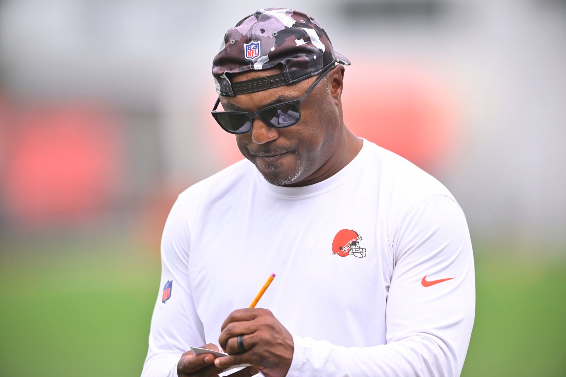 FILE - Cleveland Browns defensive coordinator Joe Woods takes notes during an NFL football practice at the team's training facility Wednesday, June 8, 2022, in Berea, Ohio. Cleveland's defense has underperformed through five games and defensive coordinator Joe Woods is feeling the heat from a fan base demanding better and seeing little improvement. (AP Photo/David Richard, File)