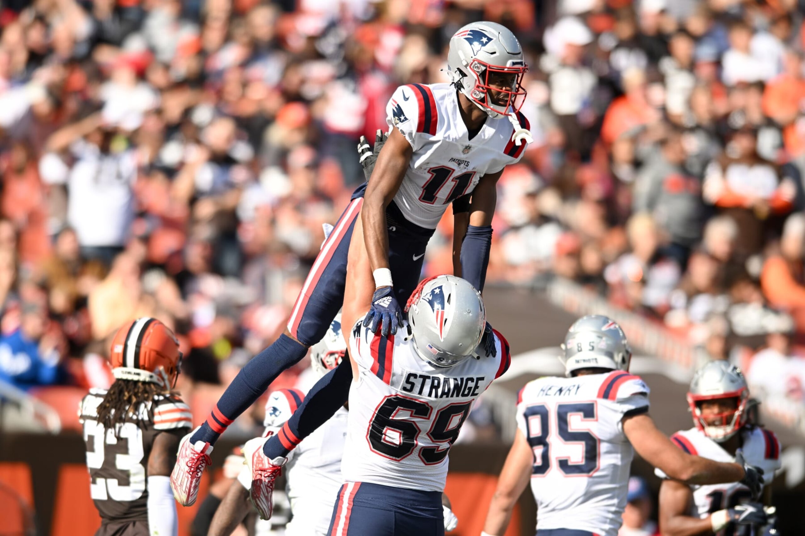 CLEVELAND, OHIO - OCTOBER 16: Cole Strange #69 of the New England Patriots celebrates with Tyquan Thornton #11 of the New England Patriots after Thornton's touchdown during the third quarter against the Cleveland Browns at FirstEnergy Stadium on October 16, 2022 in Cleveland, Ohio. (Photo by Nick Cammett/Getty Images)