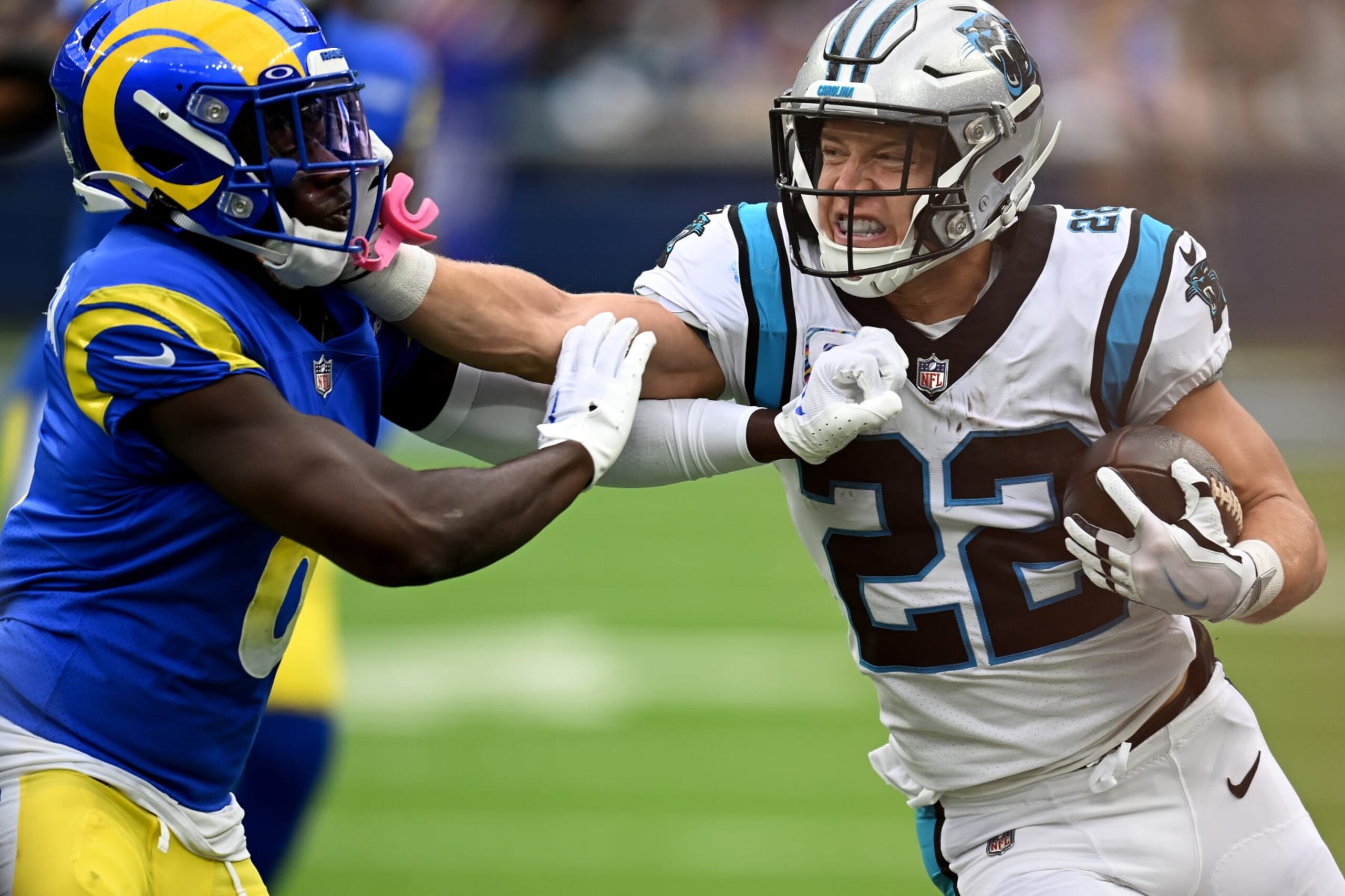 INGLEWOOD, CALIFORNIA - OCTOBER 16: Christian McCaffrey #22 of the Carolina Panthers stiff arms Derion Kendrick #6 of the Los Angeles Rams during the first quarter at SoFi Stadium on October 16, 2022 in Inglewood, California. (Photo by John McCoy/Getty Images)