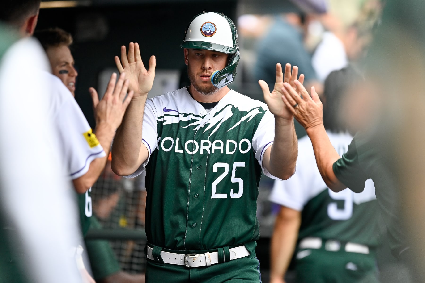 DENVER, CO - AUGUST 14: C.J. Cron #25 of the Colorado Rockies celebrates in the dugout after scoring a run in the sixth inning of a game against the Arizona Diamondbacks at Coors Field on August 14, 2022 in Denver, Colorado. (Photo by Dustin Bradford/Getty Images)