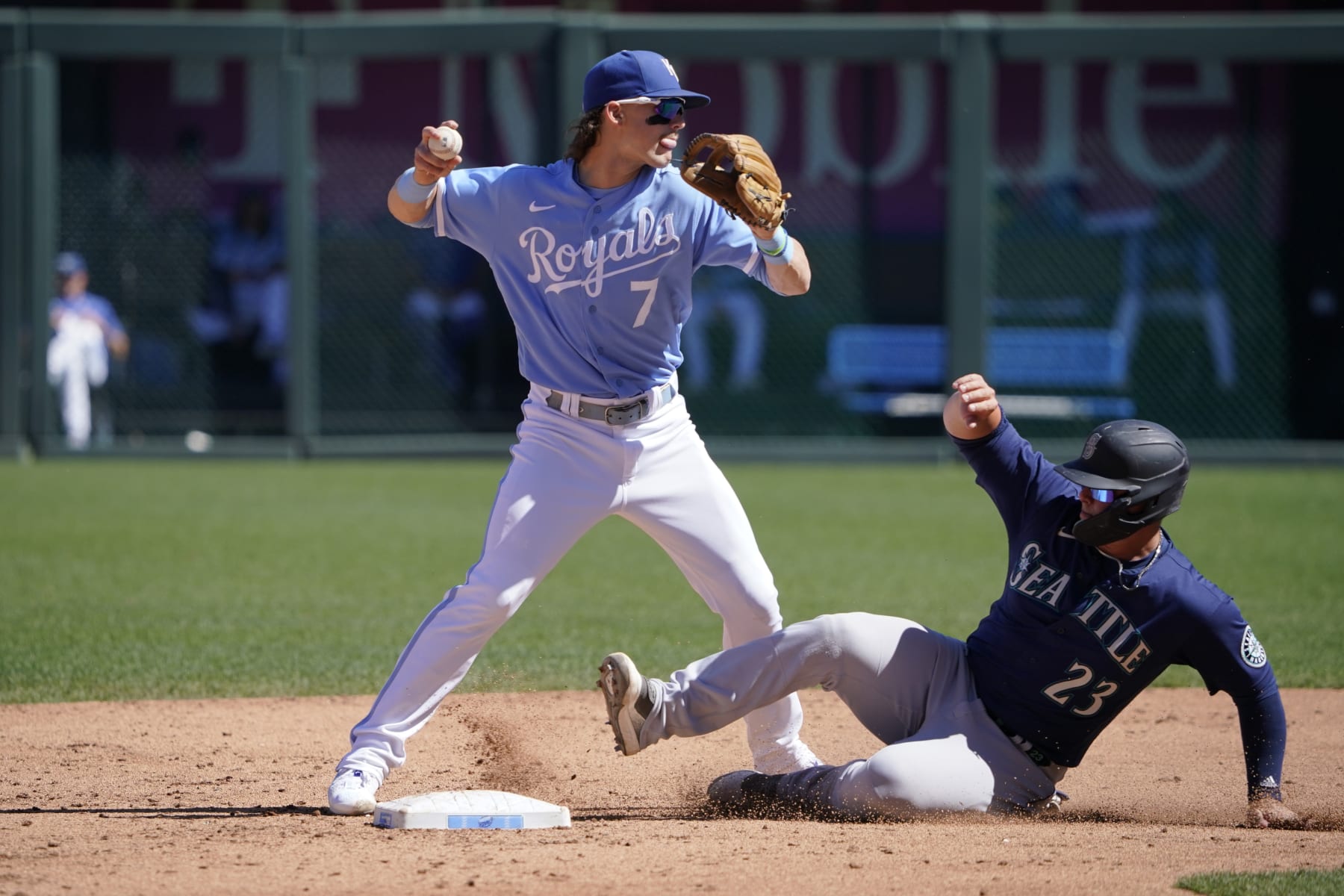 KANSAS CITY, MISSOURI - SEPTEMBER 25:  Bobby Witt Jr. #7 of the Kansas City Royals throws past Ty France #23 of the Seattle Mariners to first to complete a double play at Kauffman Stadium on September 25, 2022 in Kansas City, Missouri. (Photo by Ed Zurga/Getty Images)
