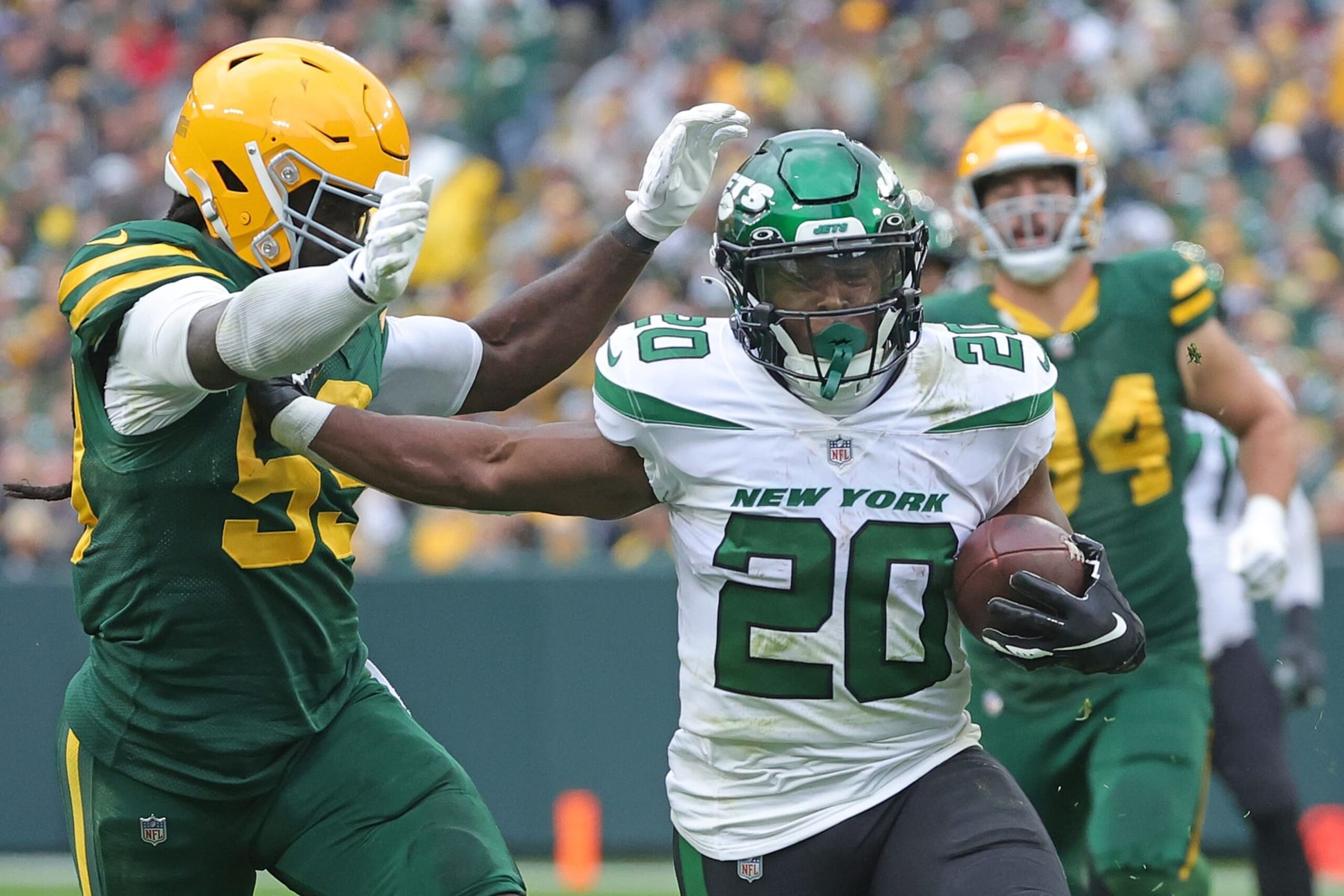 GREEN BAY, WISCONSIN - OCTOBER 16: Breece Hall #20 of the New York Jets is pursued by Kingsley Enagbare #55 of the Green Bay Packers during a game at Lambeau Field on October 16, 2022 in Green Bay, Wisconsin.  The Jets defeated the Packers 27-10. (Photo by Stacy Revere/Getty Images)