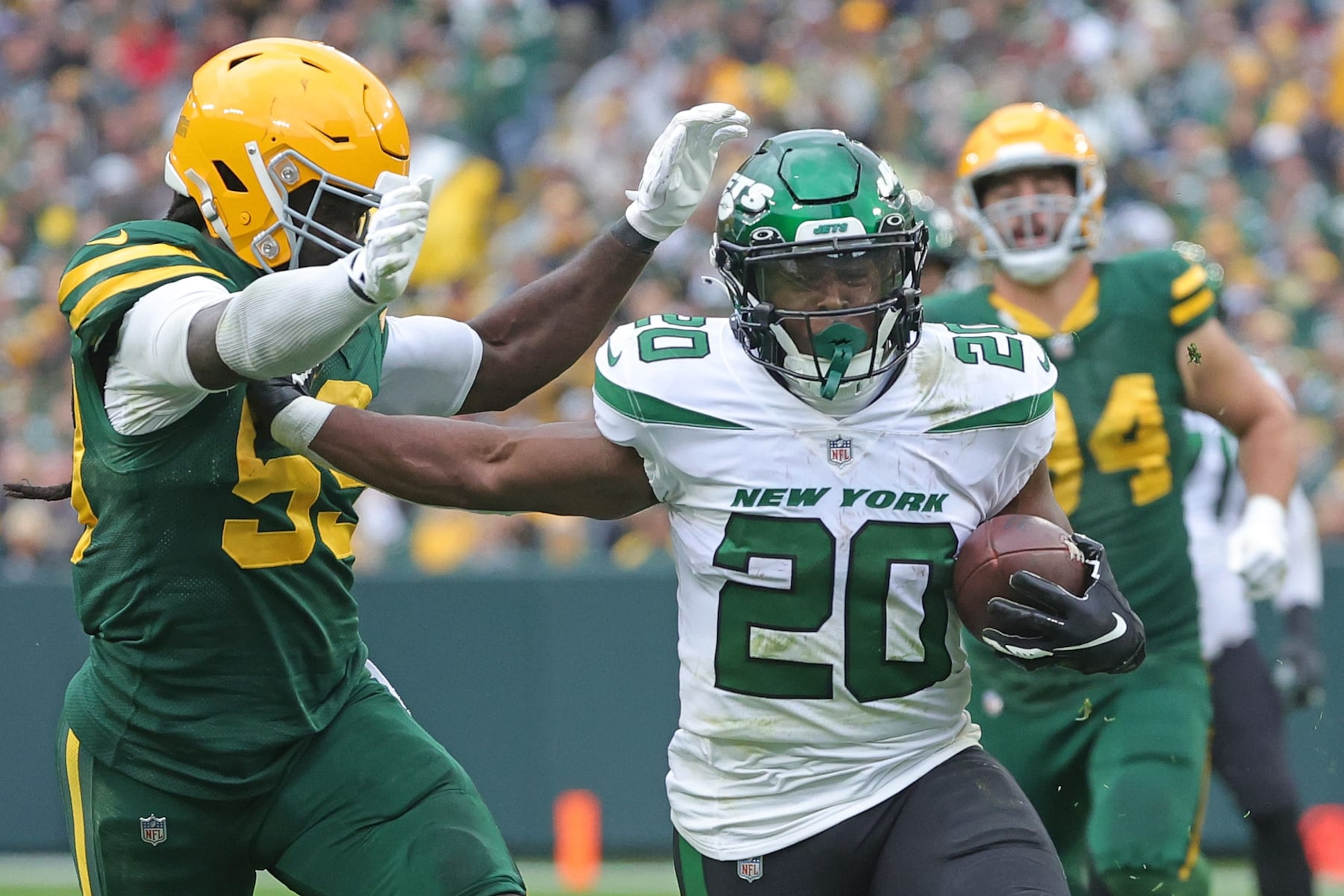 GREEN BAY, WISCONSIN - OCTOBER 16: Breece Hall #20 of the New York Jets is pursued by Kingsley Enagbare #55 of the Green Bay Packers during a game at Lambeau Field on October 16, 2022 in Green Bay, Wisconsin.  The Jets defeated the Packers 27-10. (Photo by Stacy Revere/Getty Images)