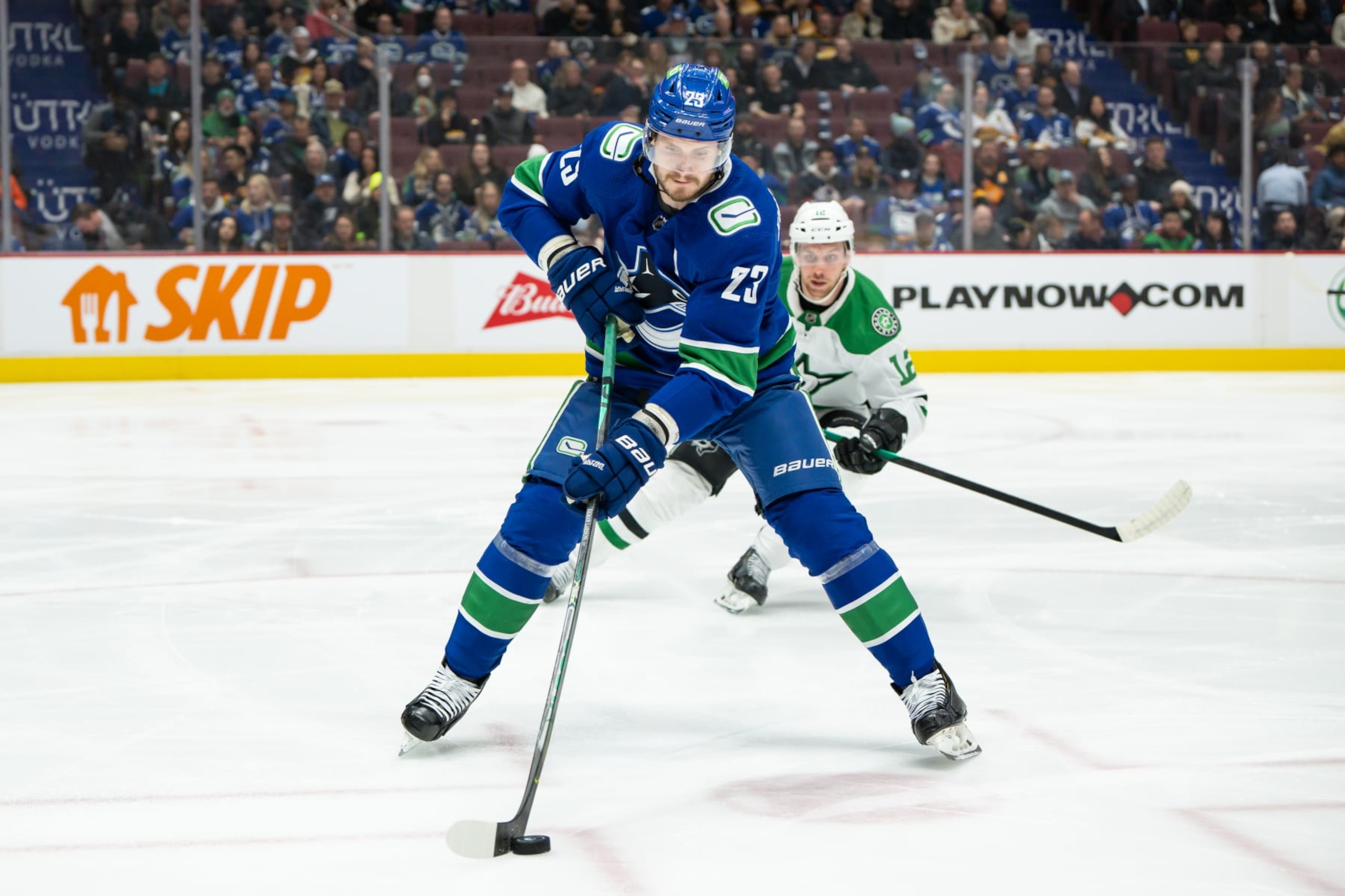 VANCOUVER, BC - APRIL 18: Vancouver Canucks defenseman Oliver Ekman-Larsson (23) skates with the puck ahead of Dallas Stars center Radek Faksa (12) during their NHL game at Rogers Arena on April 18, 2022 in Vancouver, British Columbia, Canada. (Photo by Derek Cain/Icon Sportswire via Getty Images)