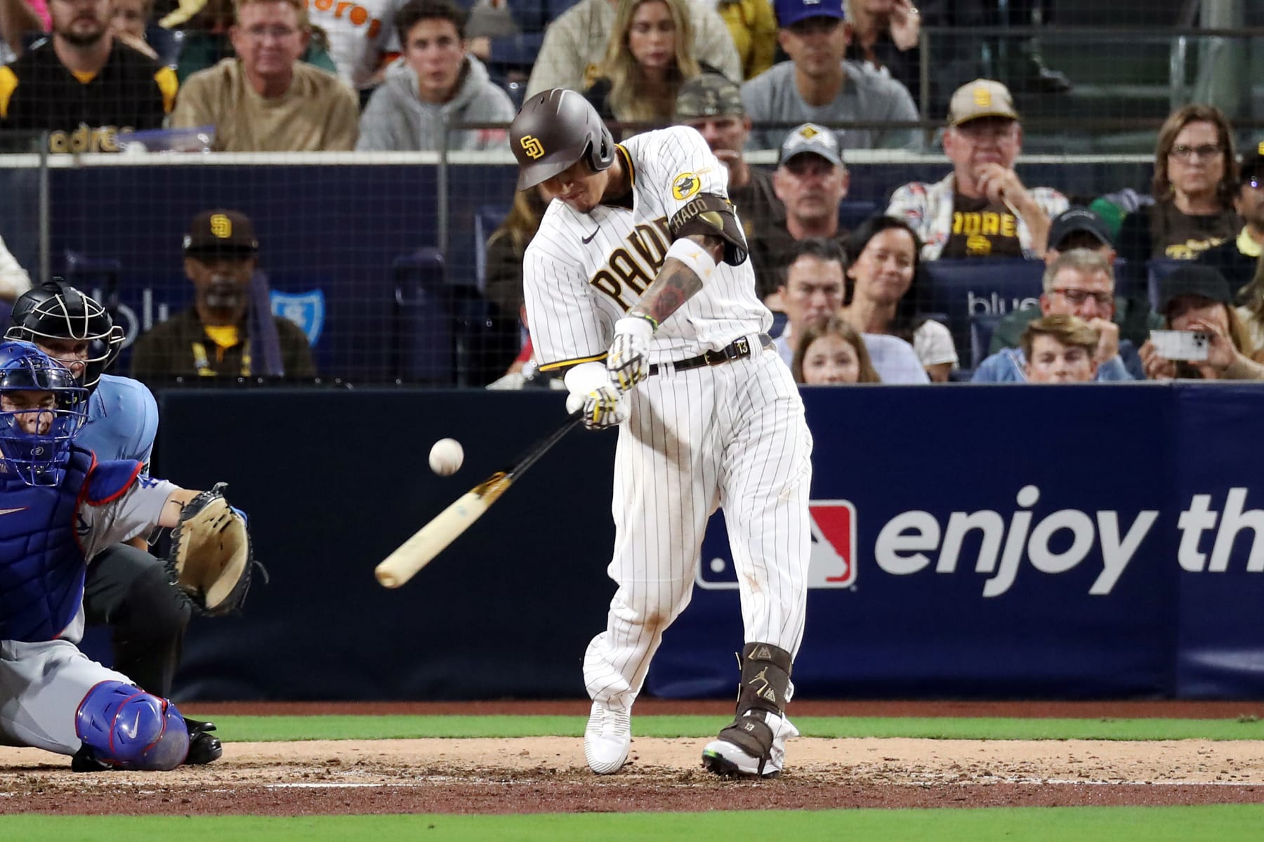 SAN DIEGO, CALIFORNIA - OCTOBER 15: Manny Machado #13 of the San Diego Padres hits a single during the sixth inning against the Los Angeles Dodgers in game four of the National League Division Series at PETCO Park on October 15, 2022 in San Diego, California. (Photo by Denis Poroy/Getty Images)