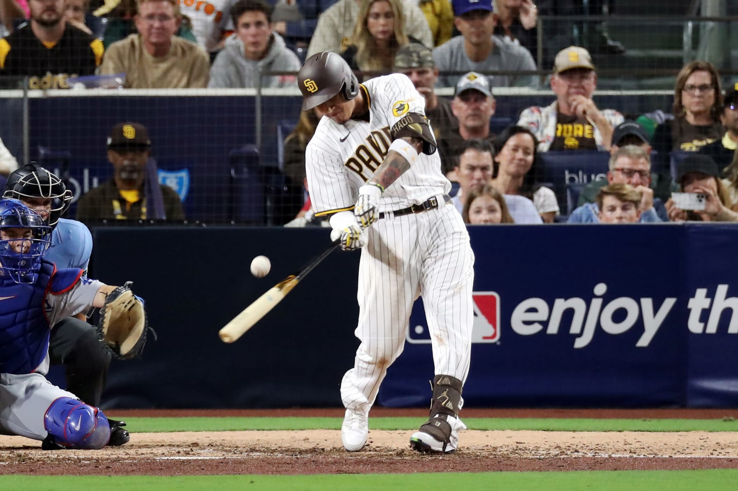 SAN DIEGO, CALIFORNIA - OCTOBER 15: Manny Machado #13 of the San Diego Padres hits a single during the sixth inning against the Los Angeles Dodgers in game four of the National League Division Series at PETCO Park on October 15, 2022 in San Diego, California. (Photo by Denis Poroy/Getty Images)