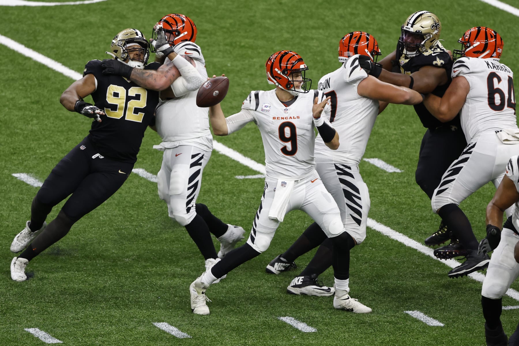 Cincinnati Bengals quarterback Joe Burrow (9) looks to pass under pressure from New Orleans Saints defensive end Marcus Davenport (92) during the second half of an NFL football game in New Orleans, Sunday, Oct. 16, 2022. (AP Photo/Butch Dill)