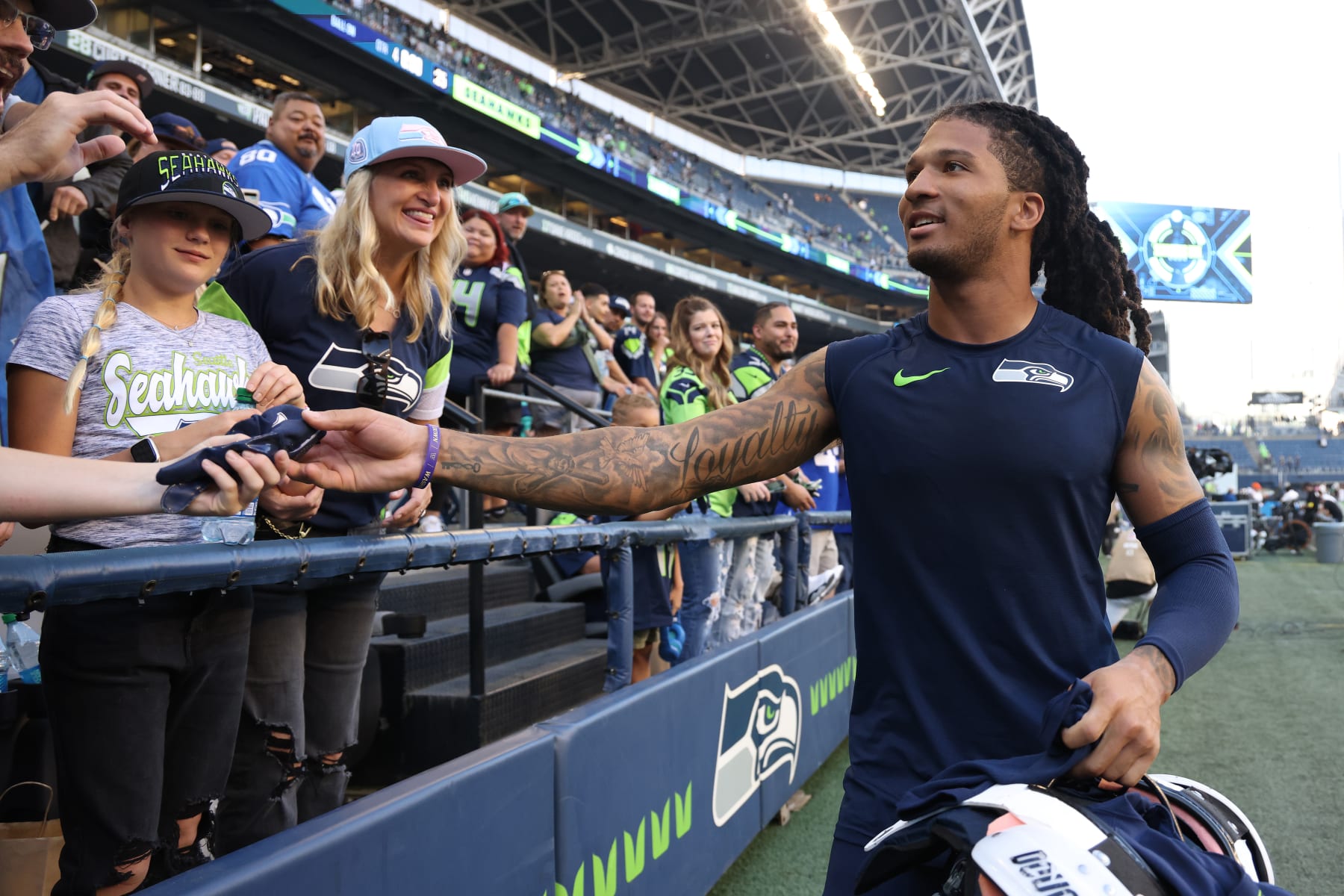 SEATTLE, WASHINGTON - OCTOBER 16: Sidney Jones IV #23 of the Seattle Seahawks gives fans a pair of gloves after a win against the Arizona Cardinals at Lumen Field on October 16, 2022 in Seattle, Washington. (Photo by Tom Hauck/Getty Images)