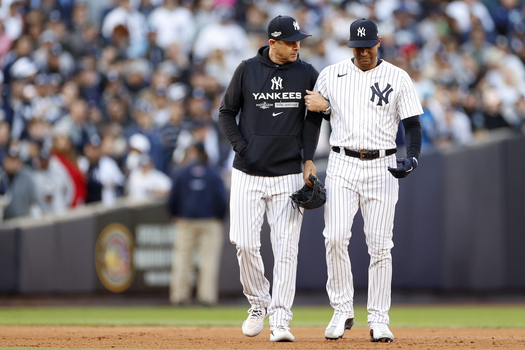 NEW YORK, NEW YORK - OCTOBER 18: Manager Aaron Boone 
 walks off the field with Aaron Hicks #31 of the New York Yankees after suffering an injury against the Cleveland Guardians during the third inning in game five of the American League Division Series at Yankee Stadium on October 18, 2022 in New York, New York. (Photo by Sarah Stier/Getty Images)