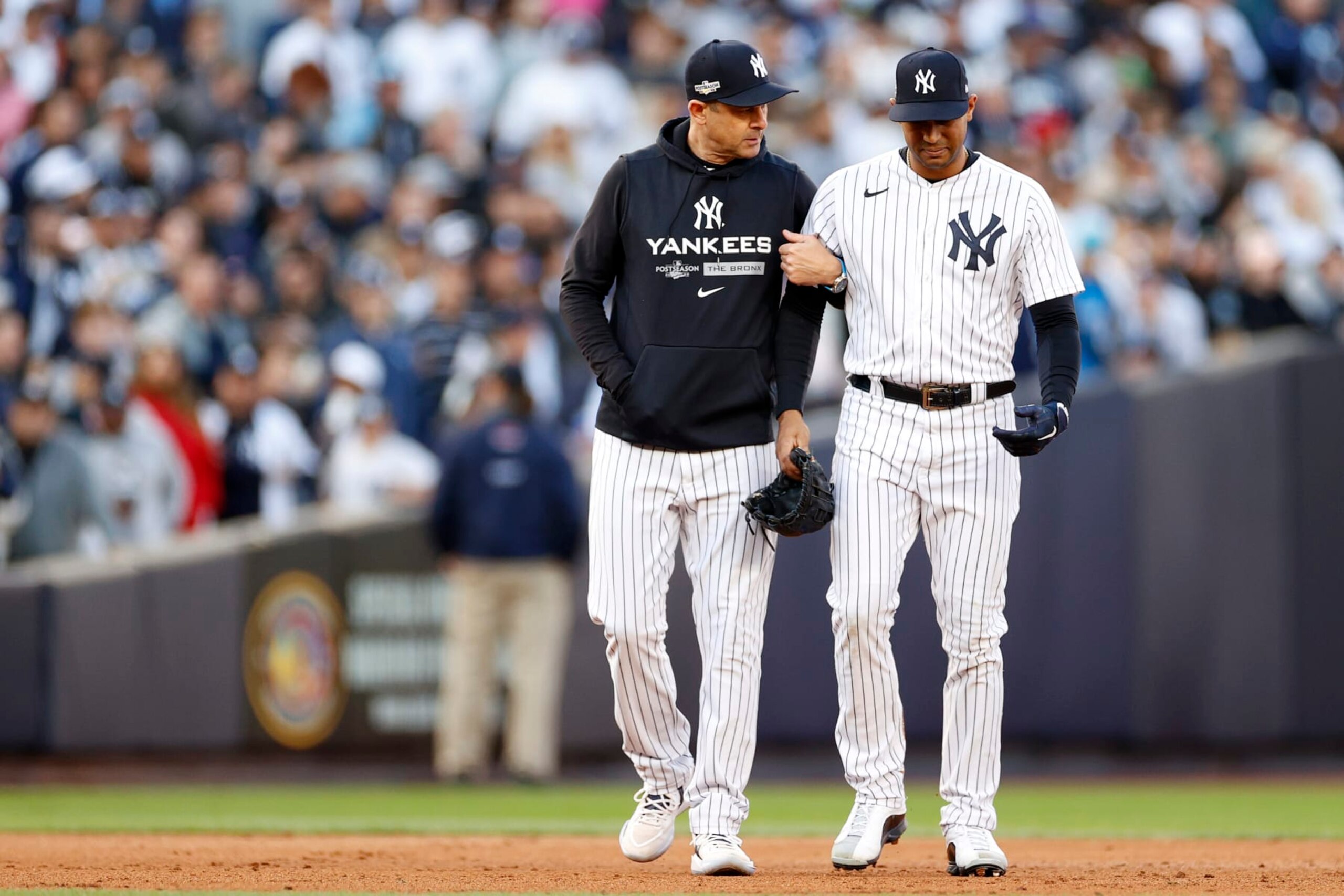 NEW YORK, NEW YORK - OCTOBER 18: Manager Aaron Boone 
 walks off the field with Aaron Hicks #31 of the New York Yankees after suffering an injury against the Cleveland Guardians during the third inning in game five of the American League Division Series at Yankee Stadium on October 18, 2022 in New York, New York. (Photo by Sarah Stier/Getty Images)