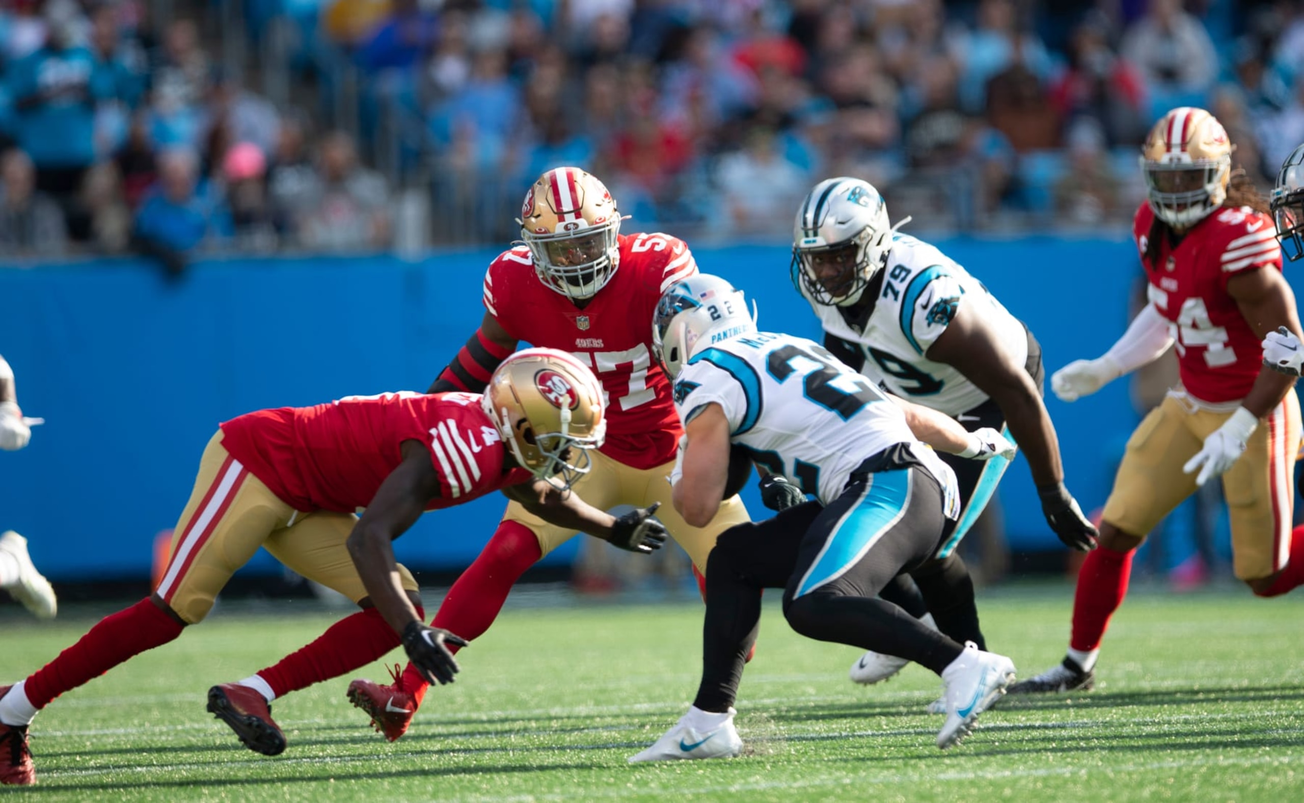 CHARLOTTE, NC - OCTOBER 9: Dre Greenlaw #57 and Emmanuel Moseley #4 of the San Francisco 49ers tackle Christian McCaffrey #22 of the Carolina Panthers during the game at Bank of America Stadium on October 9, 2022 in Charlotte, North Carolina. The 49ers defeated the Panthers 37-15. (Photo by Michael Zagaris/San Francisco 49ers/Getty Images)