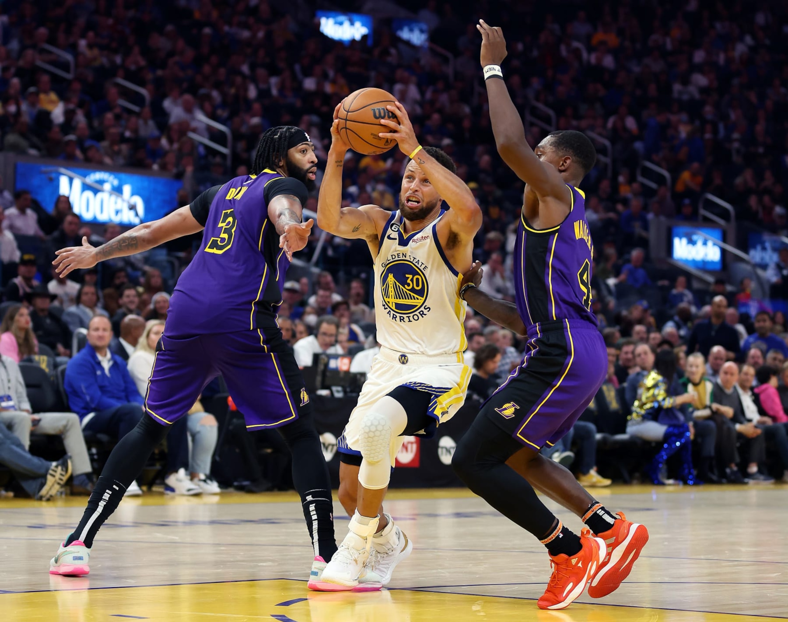 SAN FRANCISCO, CALIFORNIA - OCTOBER 18:  Stephen Curry #30 of the Golden State Warriors drives toward the basket as Lonnie Walker IV #4 and Anthony Davis #3 of the Los Angeles Lakers defend during the 1st half of the game at Chase Center on October 18, 2022 in San Francisco, California. NOTE TO USER: User expressly acknowledges and agrees that, by downloading and or using this photograph, User is consenting to the terms and conditions of the Getty Images License Agreement. (Photo by Ezra Shaw/Getty Images)