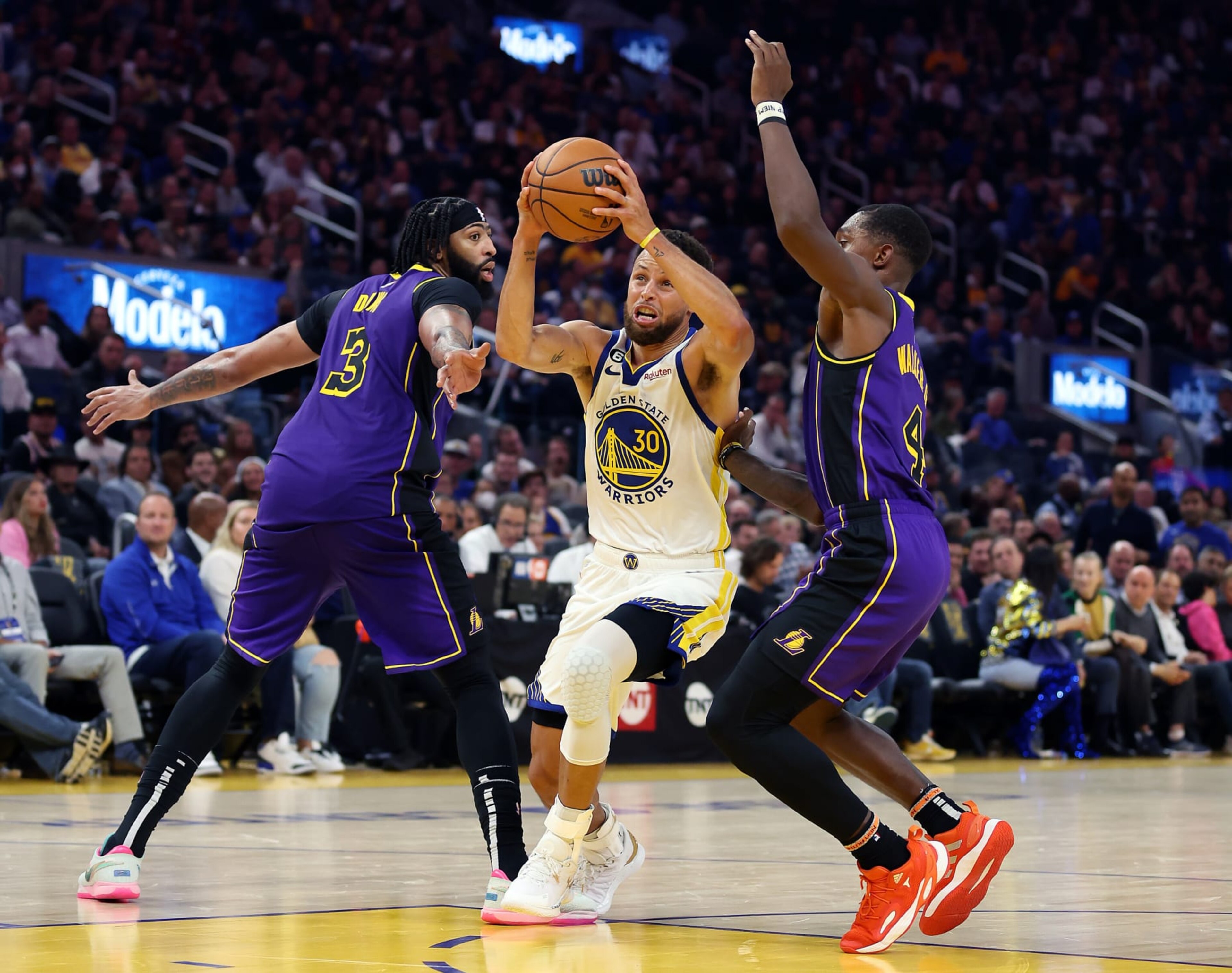 SAN FRANCISCO, CALIFORNIA - OCTOBER 18:  Stephen Curry #30 of the Golden State Warriors drives toward the basket as Lonnie Walker IV #4 and Anthony Davis #3 of the Los Angeles Lakers defend during the 1st half of the game at Chase Center on October 18, 2022 in San Francisco, California. NOTE TO USER: User expressly acknowledges and agrees that, by downloading and or using this photograph, User is consenting to the terms and conditions of the Getty Images License Agreement. (Photo by Ezra Shaw/Getty Images)