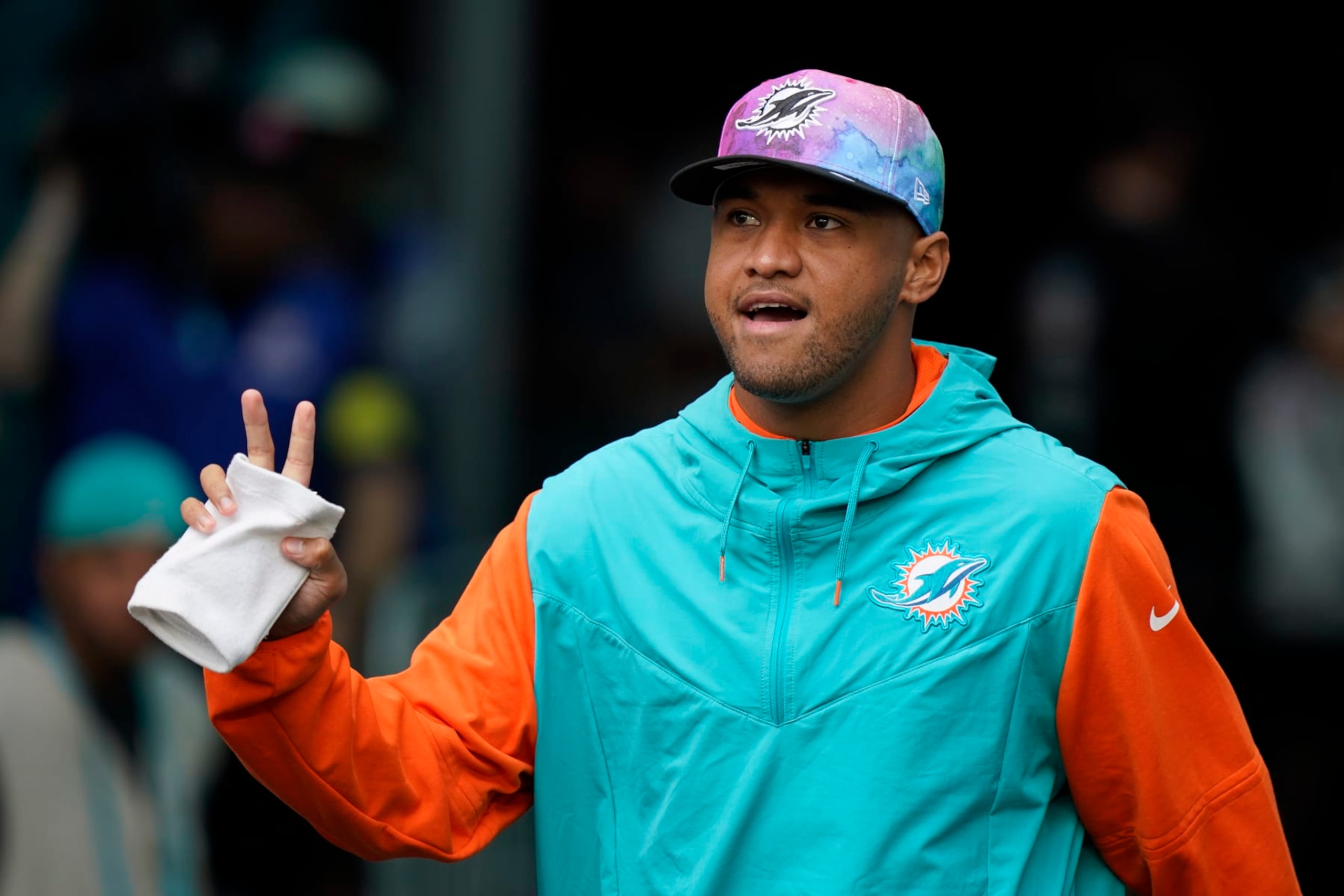 Miami Dolphins quarterback Tua Tagovailoa (1) walks onto the field, not dressed to play, ahead of an NFL football game against the Minnesota Vikings, Sunday, Oct. 16, 2022, in Miami Gardens, Fla. (AP Photo/Wilfredo Lee)