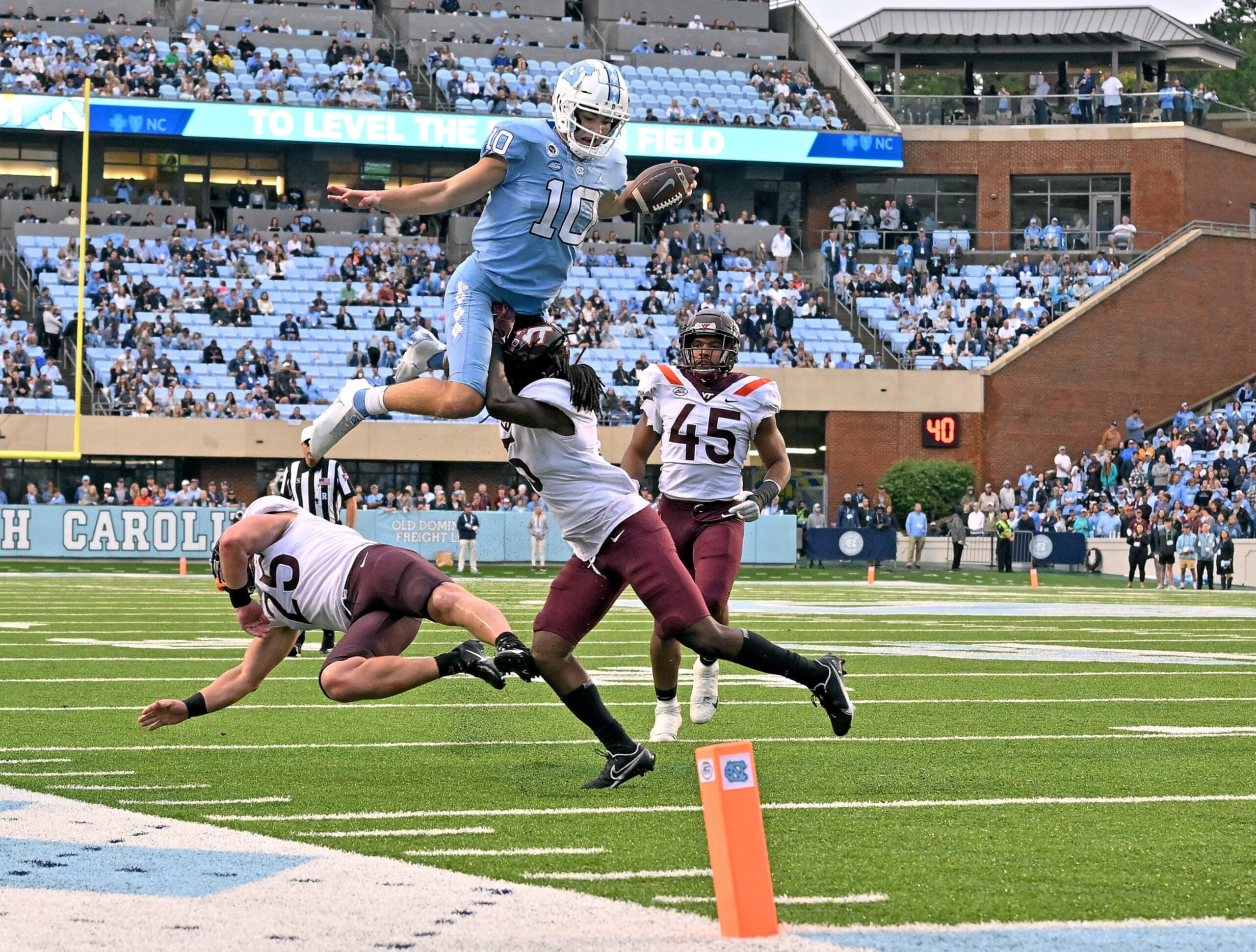 CHAPEL HILL, NORTH CAROLINA - OCTOBER 01: Drake Maye #10 of the North Carolina Tar Heels hurdles Nasir Peoples #5 of the Virginia Tech Hokies during the second half of their game at Kenan Memorial Stadium on October 01, 2022 in Chapel Hill, North Carolina. (Photo by Grant Halverson/Getty Images)