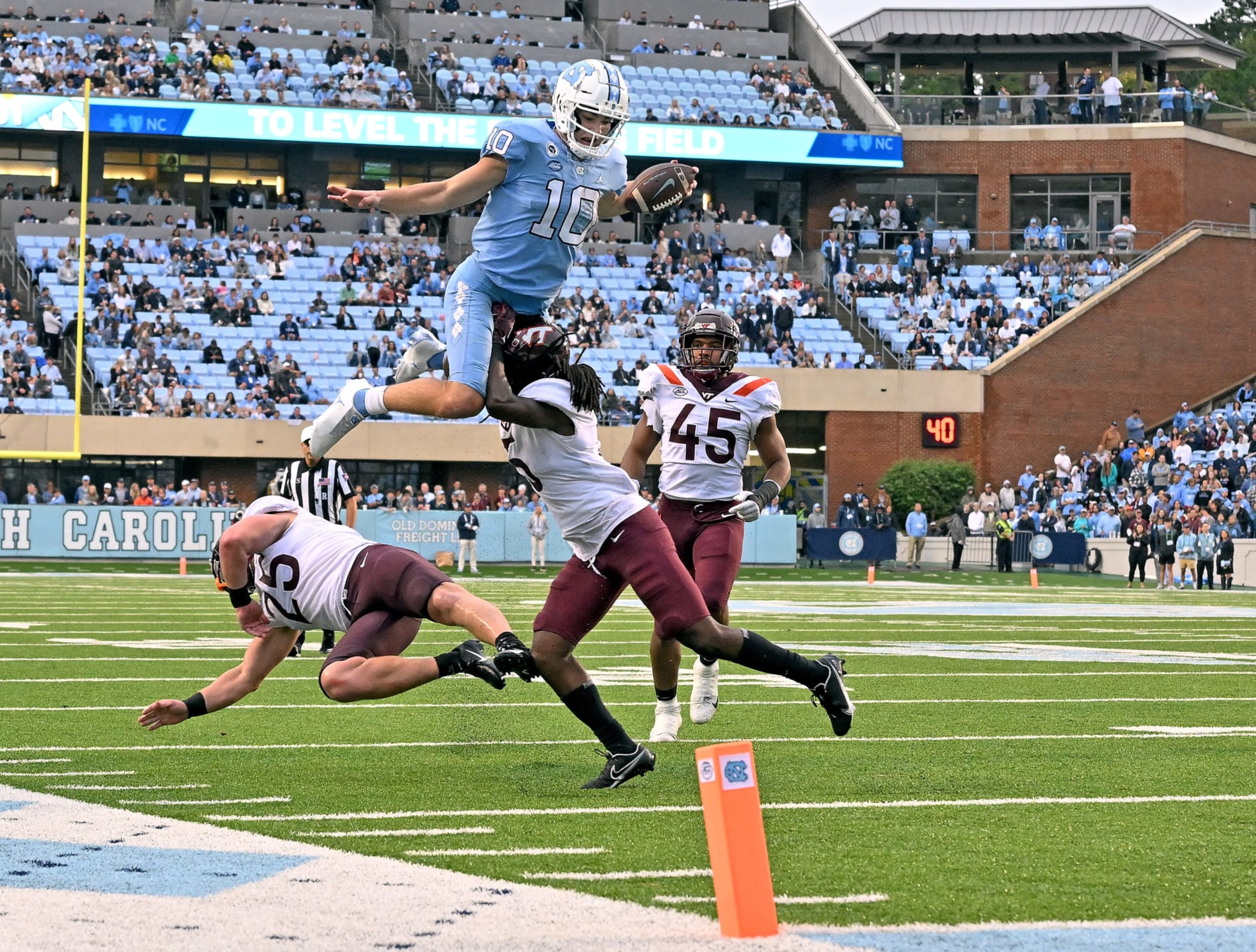 CHAPEL HILL, NORTH CAROLINA - OCTOBER 01: Drake Maye #10 of the North Carolina Tar Heels hurdles Nasir Peoples #5 of the Virginia Tech Hokies during the second half of their game at Kenan Memorial Stadium on October 01, 2022 in Chapel Hill, North Carolina. (Photo by Grant Halverson/Getty Images)