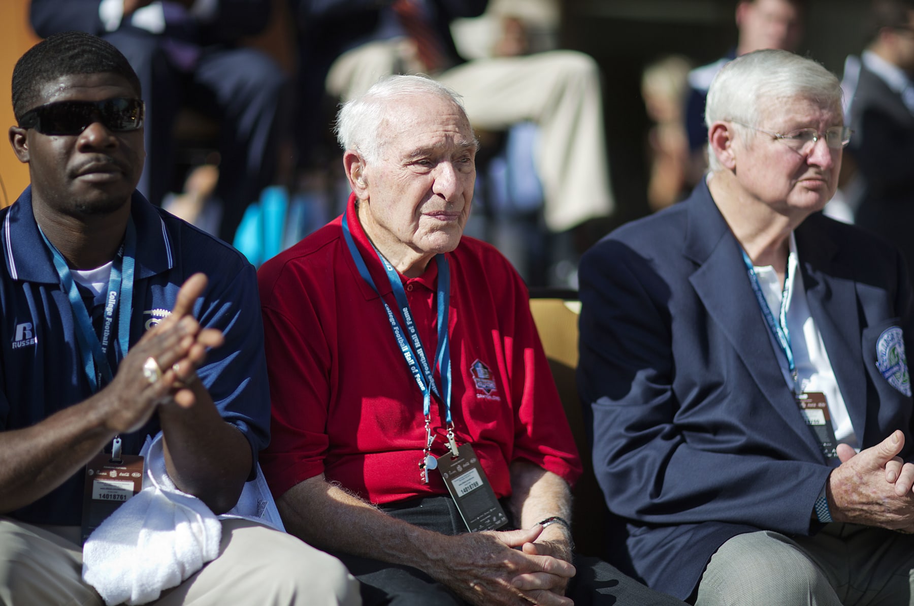 Former University of Georgia player Charley Trippi, center, is introduced at the grand opening ceremony for the new College Football Hall of Fame, Saturday, Aug. 23, 2014, in Atlanta. The new high-tech hall features an interactive experience that begins when the guest registers for a smart pass, selects a favorite school and then sees that school's helmet illuminated. (AP Photo/David Goldman)