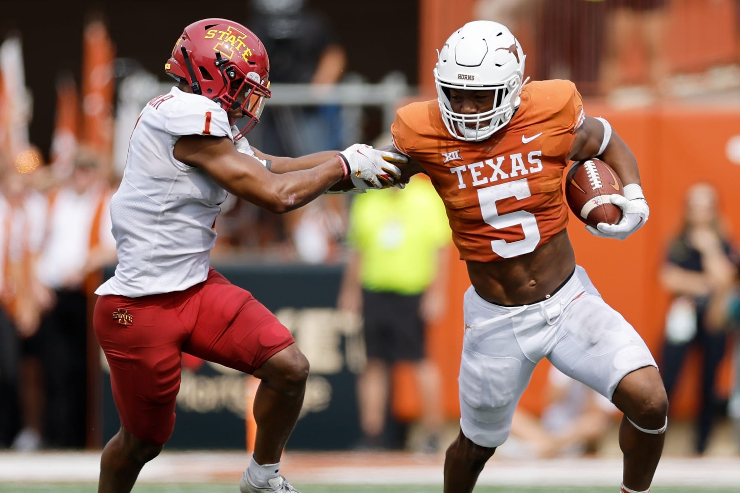 AUSTIN, TEXAS - OCTOBER 15: Bijan Robinson #5 of the Texas Longhorns gives a stiff arm to Anthony Johnson Jr. #1 of the Iowa State Cyclones in the second quarter at Darrell K Royal-Texas Memorial Stadium on October 15, 2022 in Austin, Texas. (Photo by Tim Warner/Getty Images)