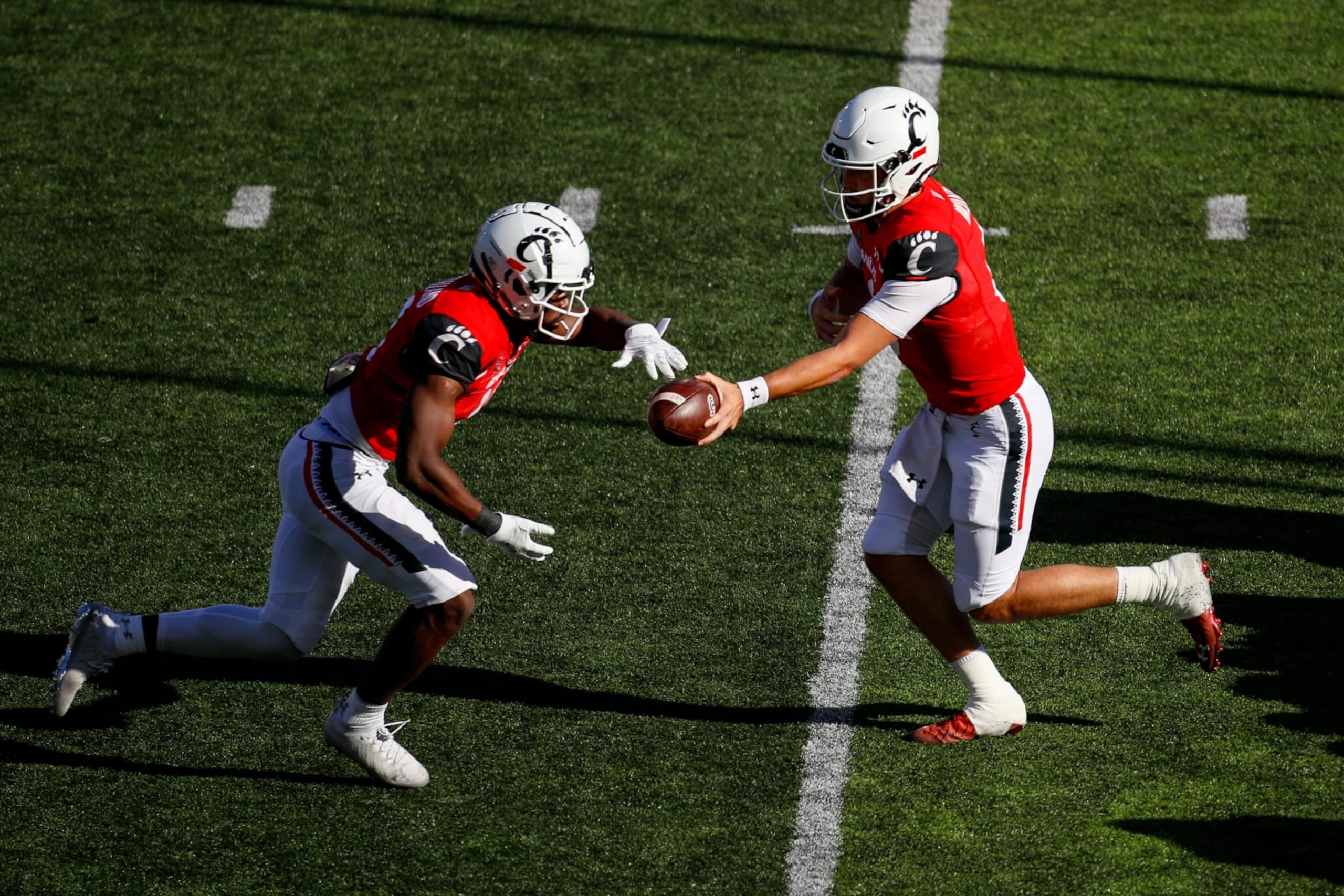 CINCINNATI, OH - OCTOBER 08: Cincinnati Bearcats quarterback Ben Bryant (6) hands the ball off to running back Charles McClelland (10) during the game against the South Florida Bulls and the Cincinnati Bearcats on October 8, 2022, at Nippert Stadium in Cincinnati, OH. (Photo by Ian Johnson/Icon Sportswire via Getty Images)
