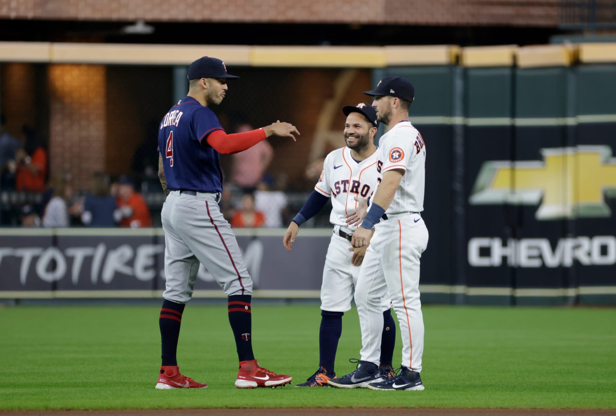 HOUSTON, TEXAS - AUGUST 25: Carlos Correa #4 of the Minnesota Twins talks with Jose Altuve #27 of the Houston Astros and Alex Bregman #2 prior to the game at Minute Maid Park on August 25, 2022 in Houston, Texas. (Photo by Tim Warner/Getty Images)
