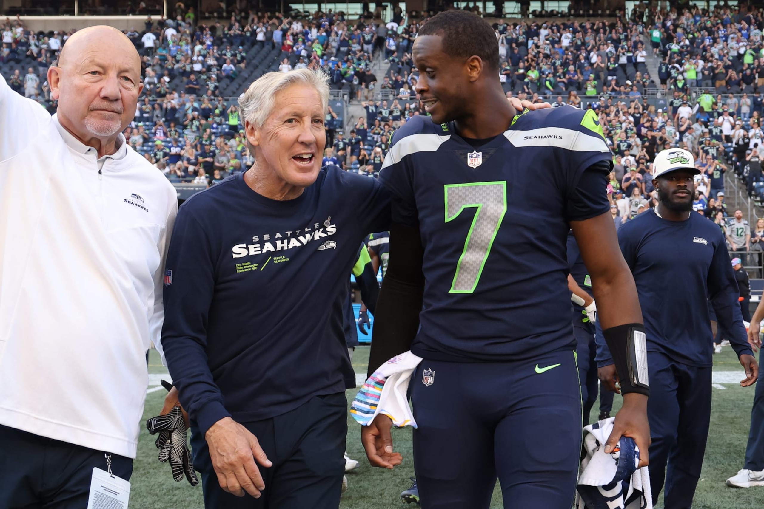 SEATTLE, WASHINGTON - OCTOBER 16: Head coach Pete Carroll of the Seattle Seahawks and Geno Smith #7 celebrate a win against the Arizona Cardinals as they walk off the  at Lumen Field on October 16, 2022 in Seattle, Washington. (Photo by Tom Hauck/Getty Images)