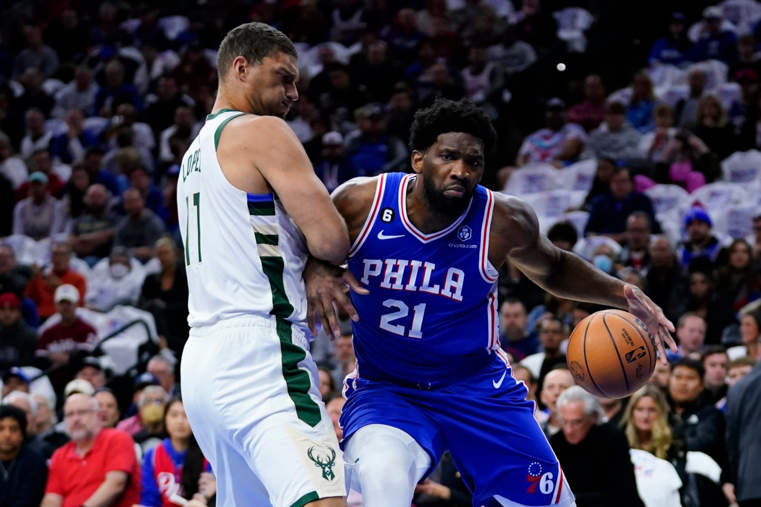 Philadelphia 76ers' Joel Embiid, right, tries to get past Milwaukee Bucks' Brook Lopez during the first half of an NBA basketball game, Thursday, Oct. 20, 2022, in Philadelphia. (AP Photo/Matt Slocum)