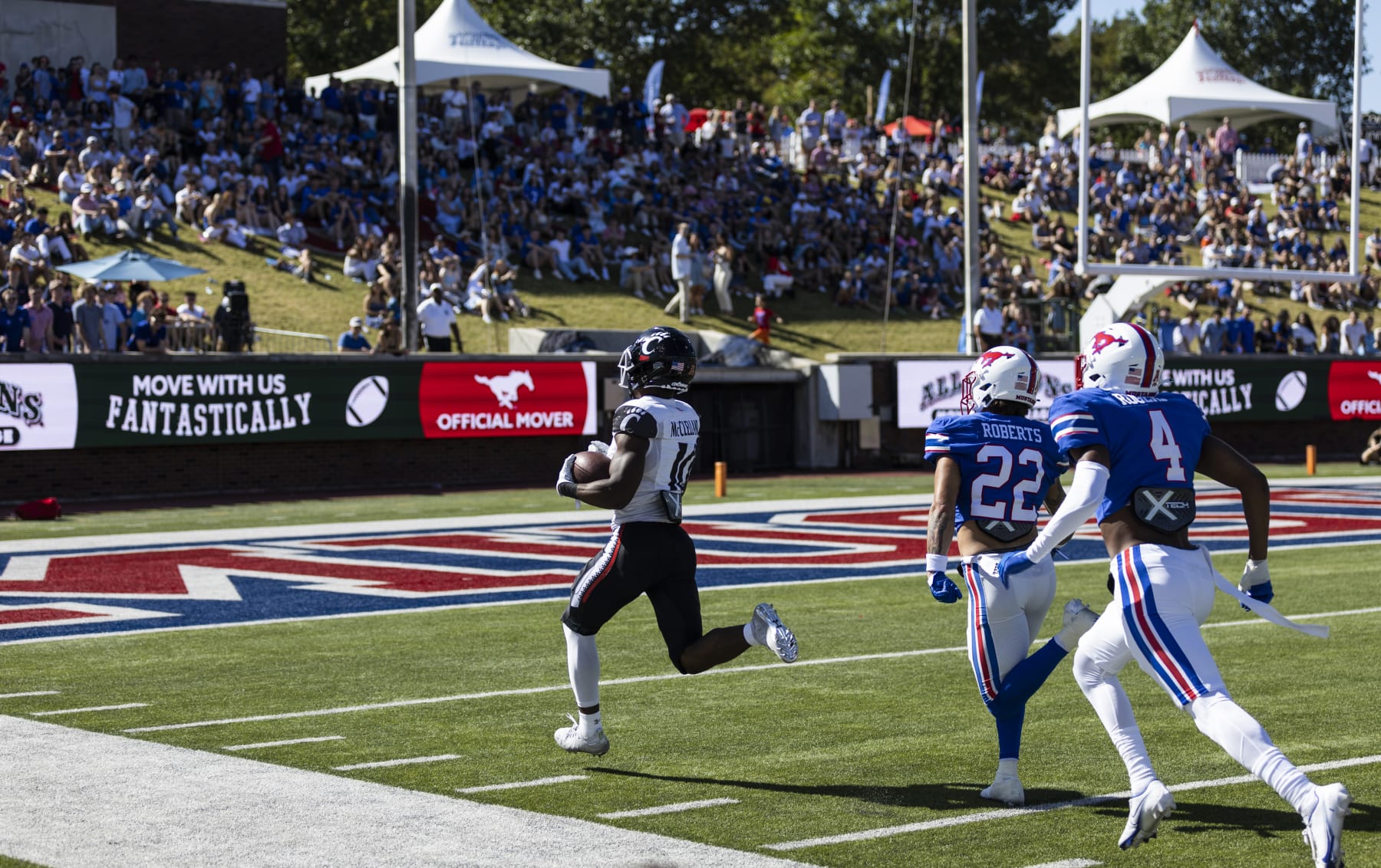 Cincinnati running back Charles McClelland (10) runs the ball into the end zone for a touchdown as SMU safety Nick Roberts (22) and cornerback Jahari Rogers (4) chase during the first half of an NCAA college football game Saturday, Oct. 22, 2022, in Dallas. (AP Photo/Brandon Wade)