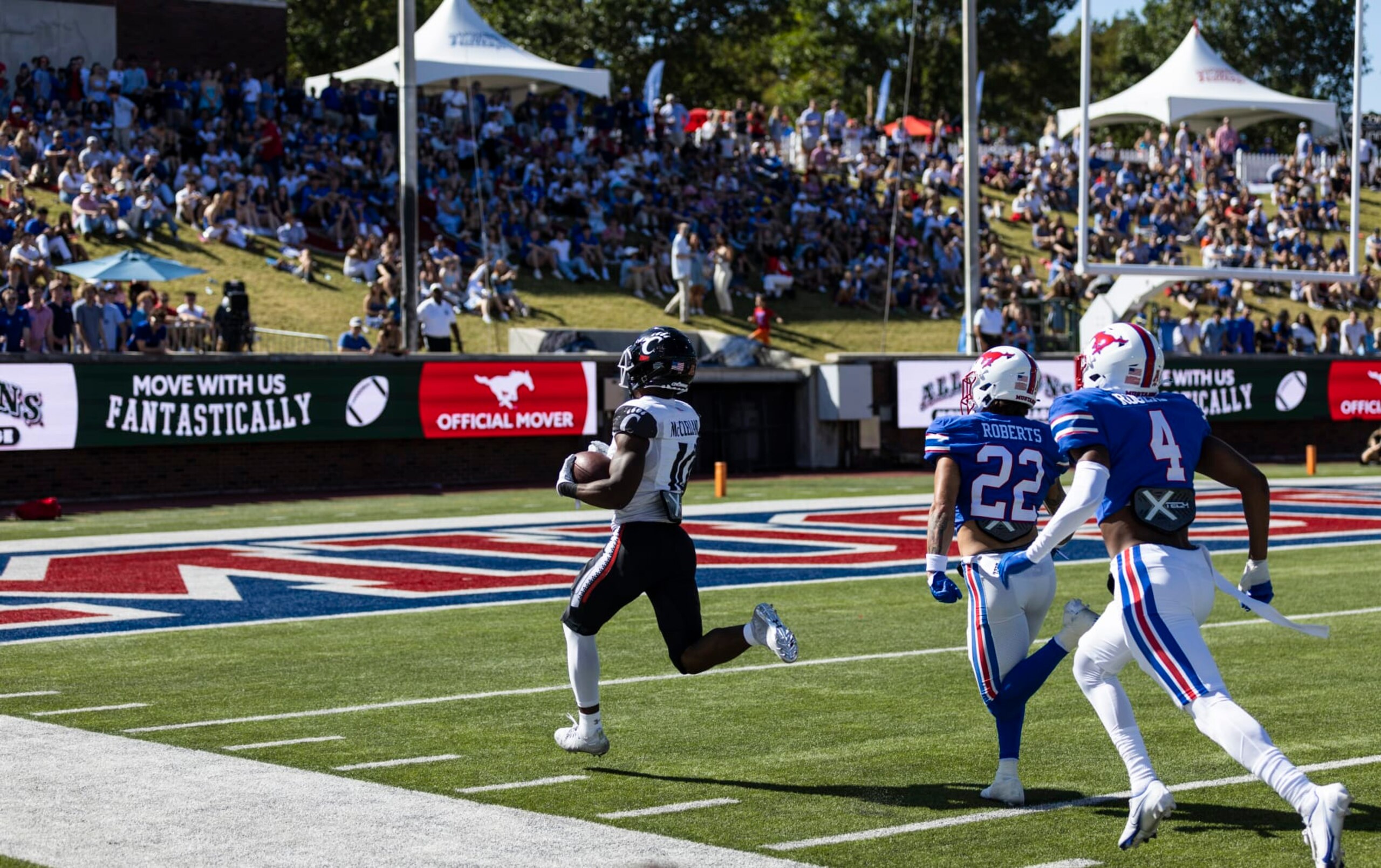 Cincinnati running back Charles McClelland (10) runs the ball into the end zone for a touchdown as SMU safety Nick Roberts (22) and cornerback Jahari Rogers (4) chase during the first half of an NCAA college football game Saturday, Oct. 22, 2022, in Dallas. (AP Photo/Brandon Wade)