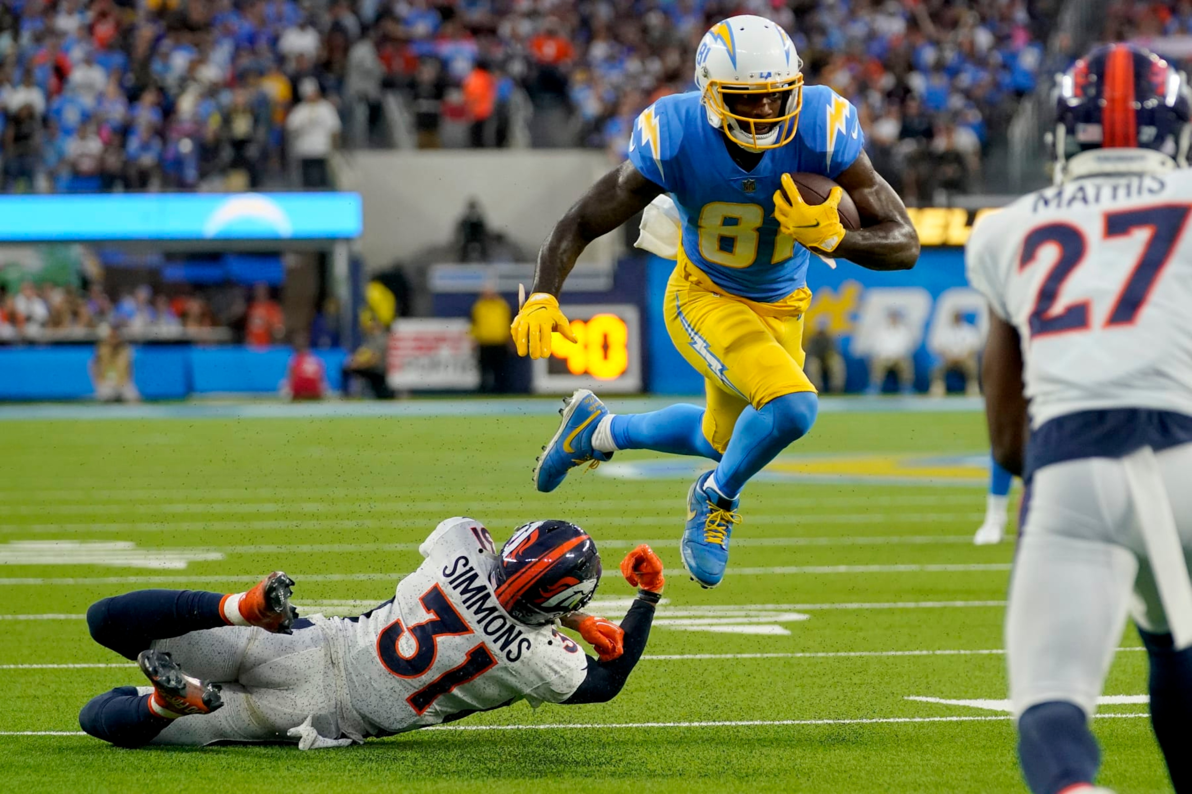 Los Angeles Chargers wide receiver Mike Williams (81) breaks the tackle of Denver Broncos safety Justin Simmons (31) during the first half of an NFL football game, Monday, Oct. 17, 2022, in Inglewood, Calif. (AP Photo/Mark J. Terrill)