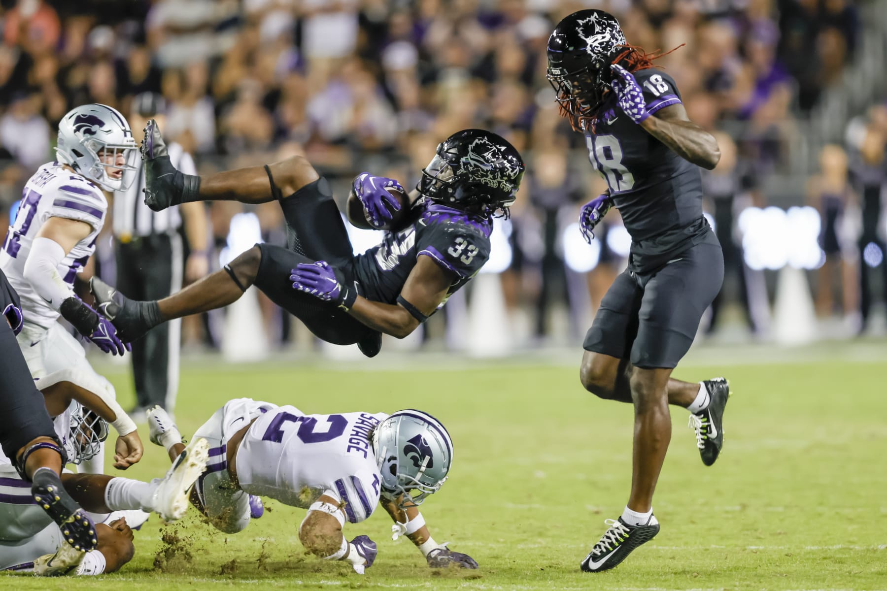 FORT WORTH, TX - OCTOBER 22: TCU Horned Frogs running back Kendre Miller (33) gets flipped in the air by Kansas State Wildcats safety Kobe Savage (2) during the game between the TCU Horned Frogs and the Kansas State Wildcats on October 22, 2022 at Amon G. Carter Stadium in Fort Worth, Texas. (Photo by Matthew Pearce/Icon Sportswire via Getty Images)