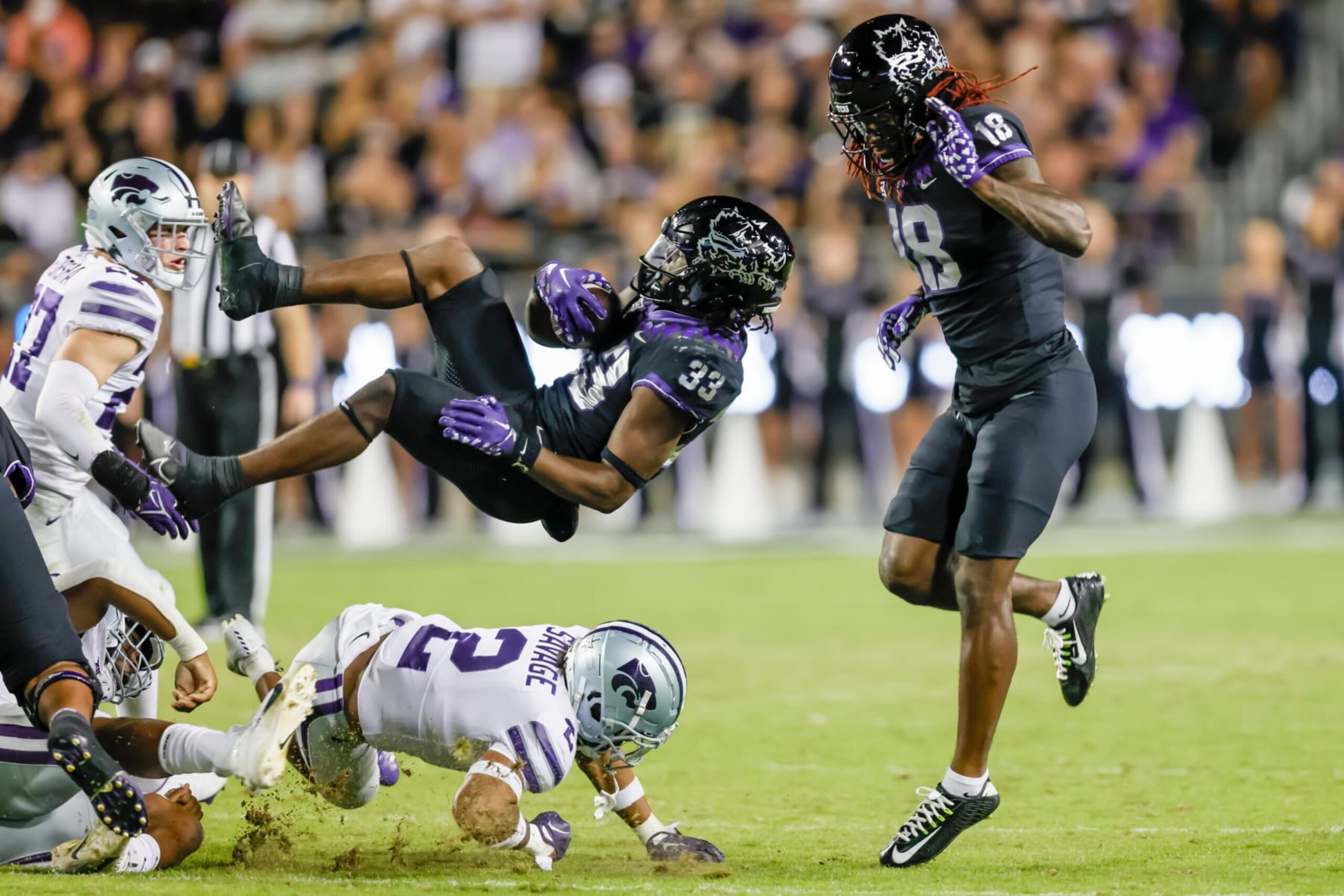 FORT WORTH, TX - OCTOBER 22: TCU Horned Frogs running back Kendre Miller (33) gets flipped in the air by Kansas State Wildcats safety Kobe Savage (2) during the game between the TCU Horned Frogs and the Kansas State Wildcats on October 22, 2022 at Amon G. Carter Stadium in Fort Worth, Texas. (Photo by Matthew Pearce/Icon Sportswire via Getty Images)