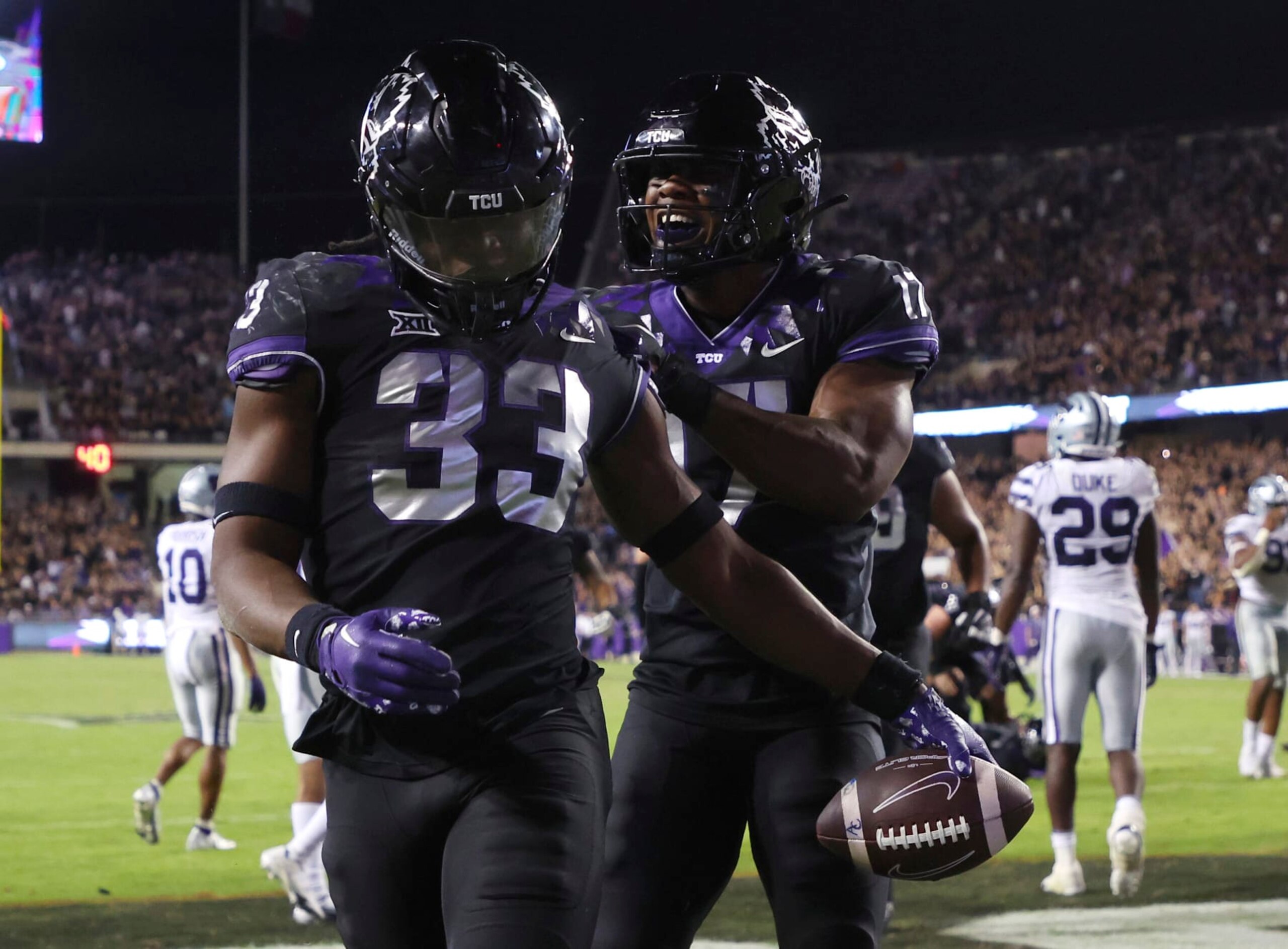 TCU running back Kendre Miller (33) and teammate Trent Battle (17) celebrate a touchdown against Kansas State during the second half of an NCAA college football game Saturday, Oct. 22, 2022, in Fort Worth, Texas. (AP Photo/Richard W. Rodriguez)